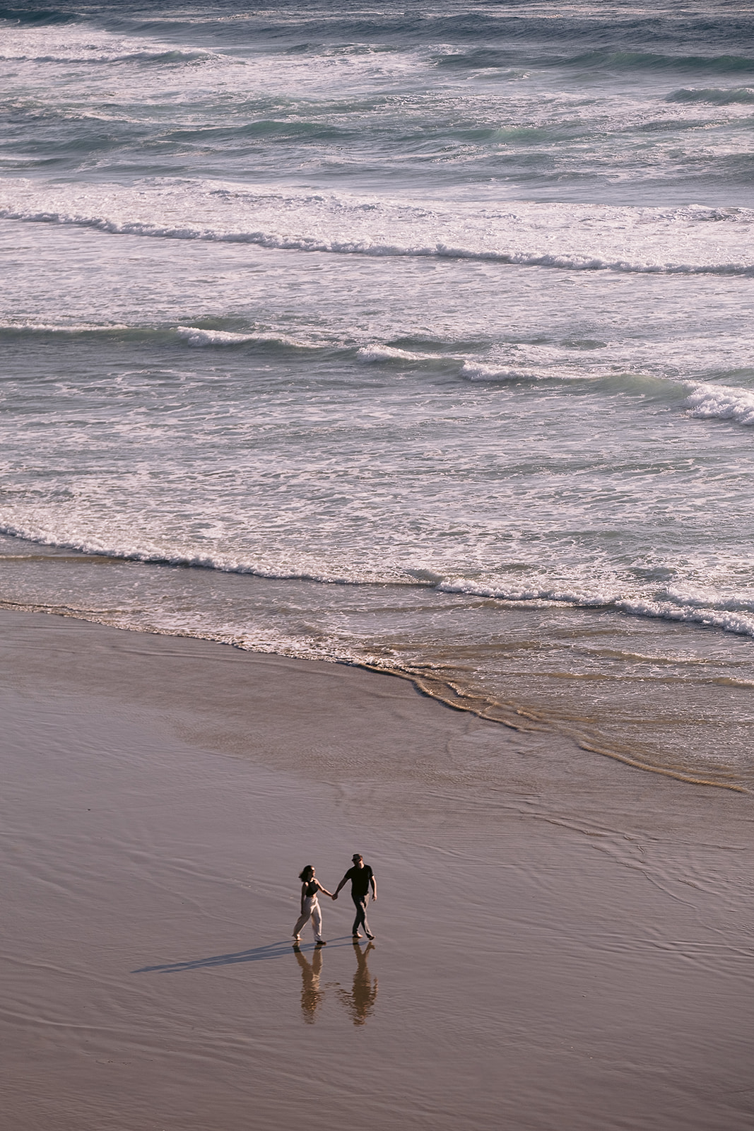 couple walks on the beach at Hug Point during engagement sessions