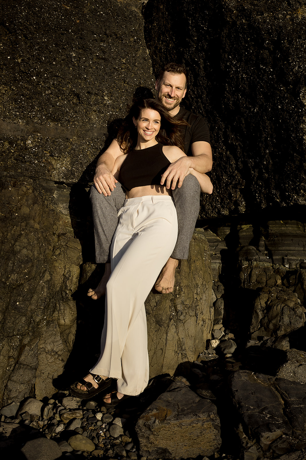 couple poses in fancy clothes during Cannon Beach Engagement session