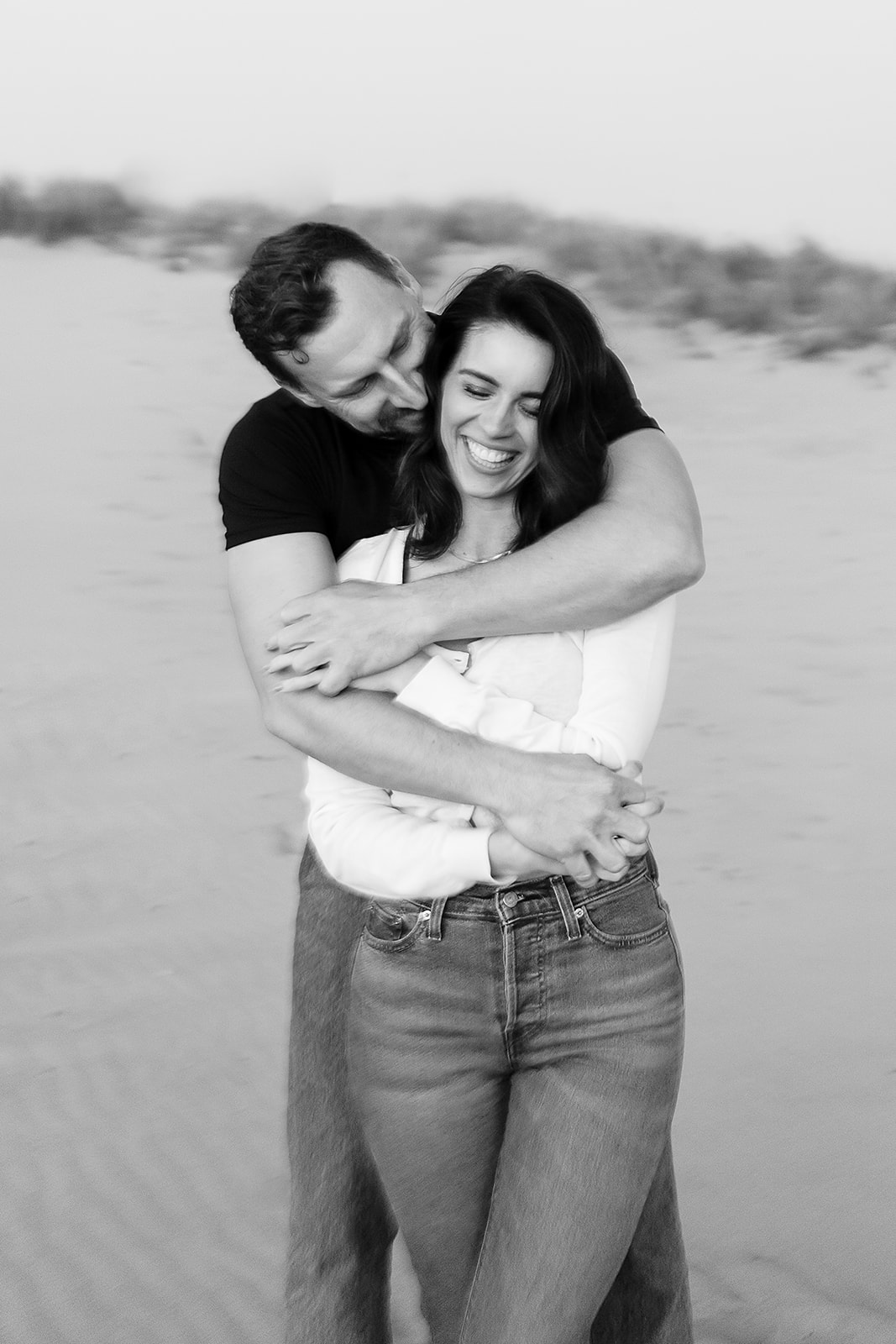 couple smiles big while embracing during Cannon Beach Engagement session