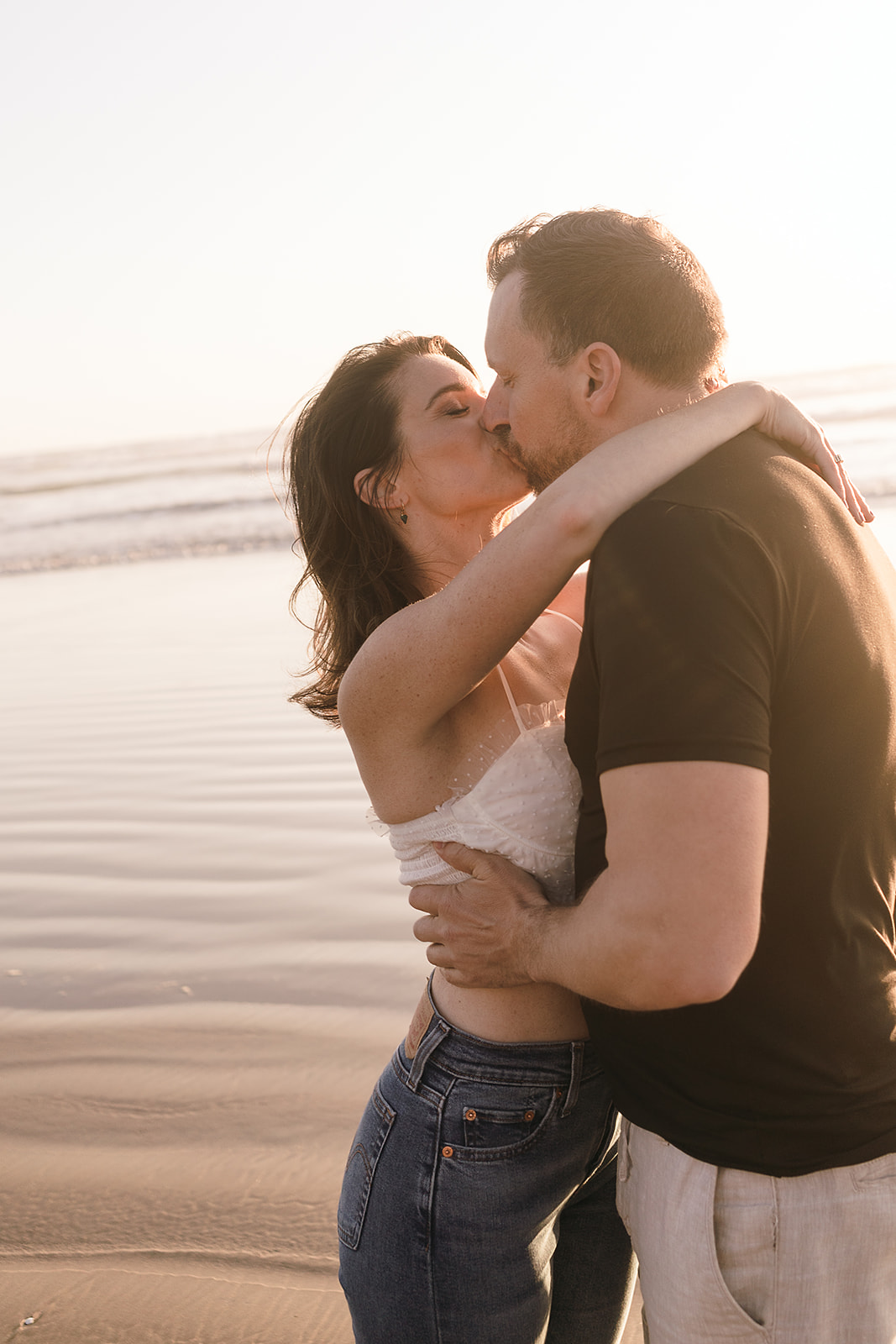 couple kisses at sunset during Cannon beach couples portrait session
