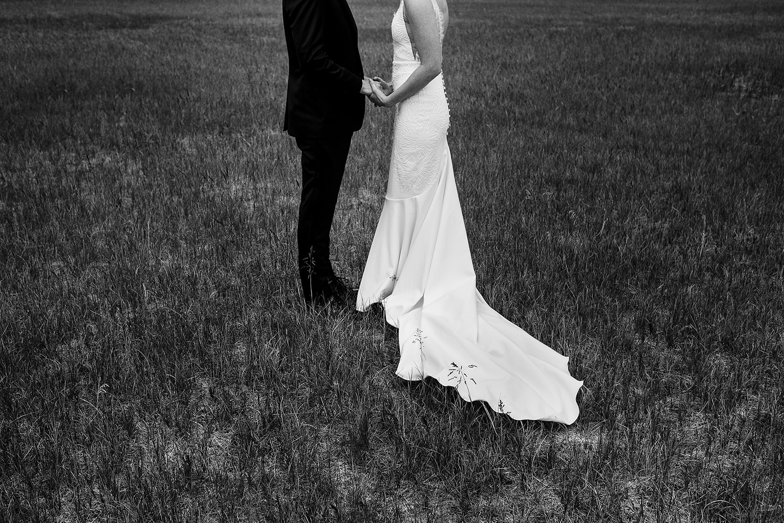 bride and groom hold hands in grass field at Mazama Ranch House Wedding