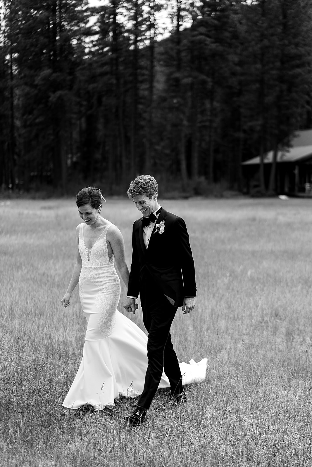 bride and groom walk through field at Mazama Ranch House Wedding