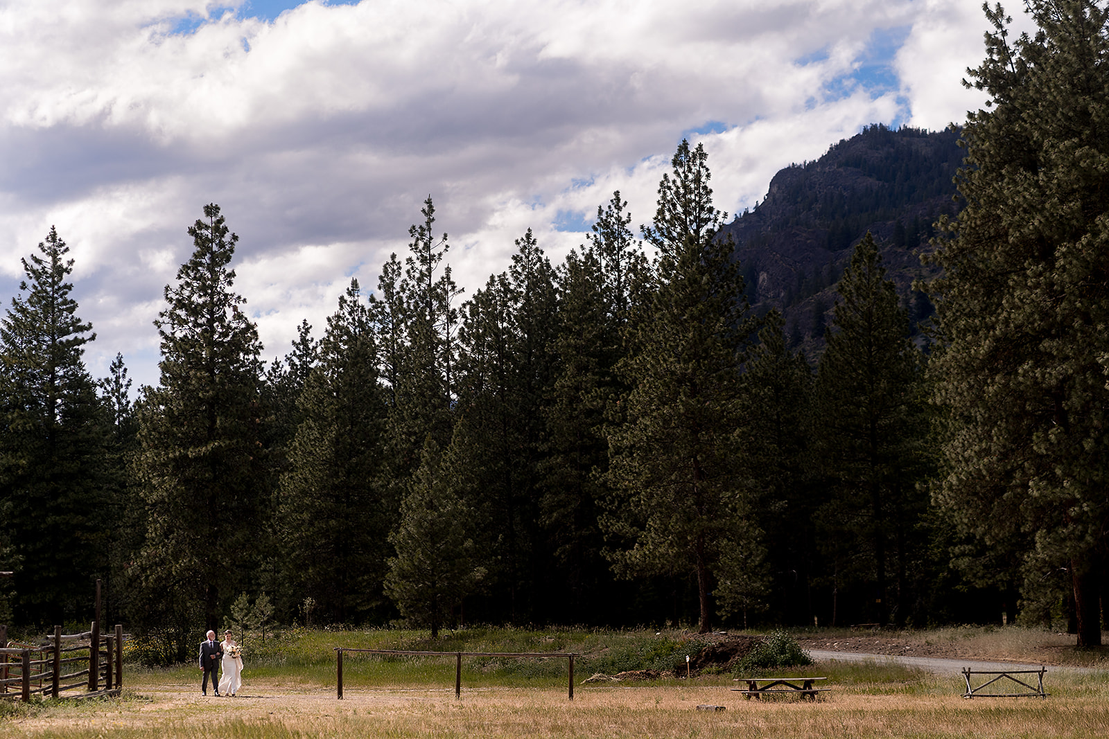father of the bride and bride walk toward wedding ceremony at Mazama Ranch House