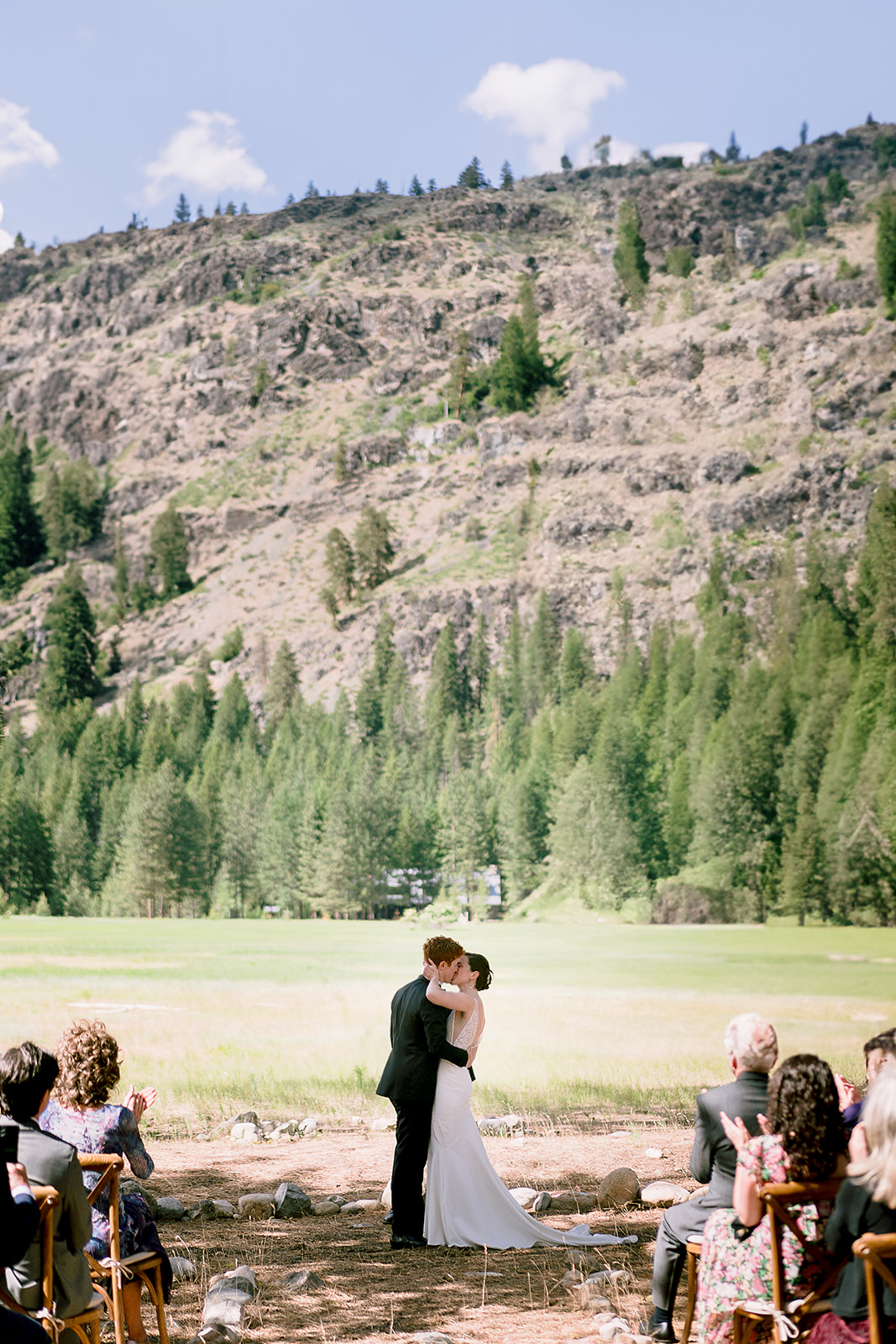 Mazama Ranch House Wedding ceremony first kiss with mountains in the background.