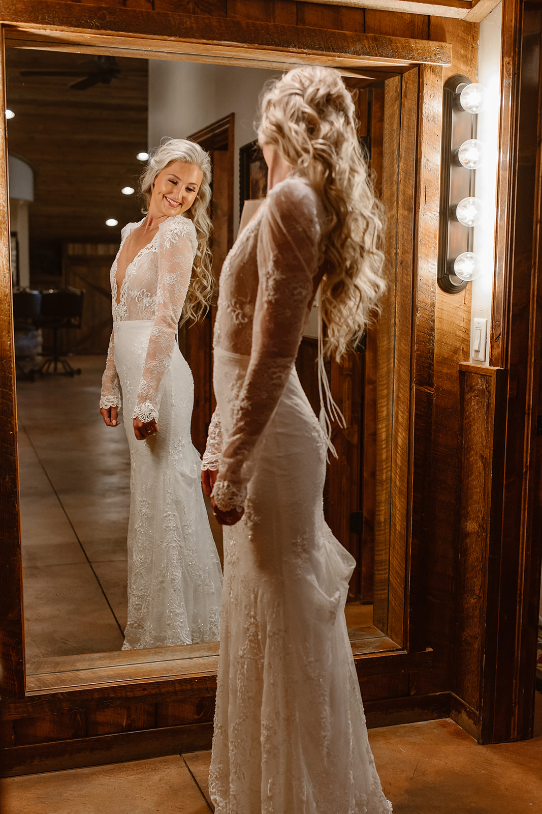 Bride looking in the mirror after getting ready for her wedding reception. 