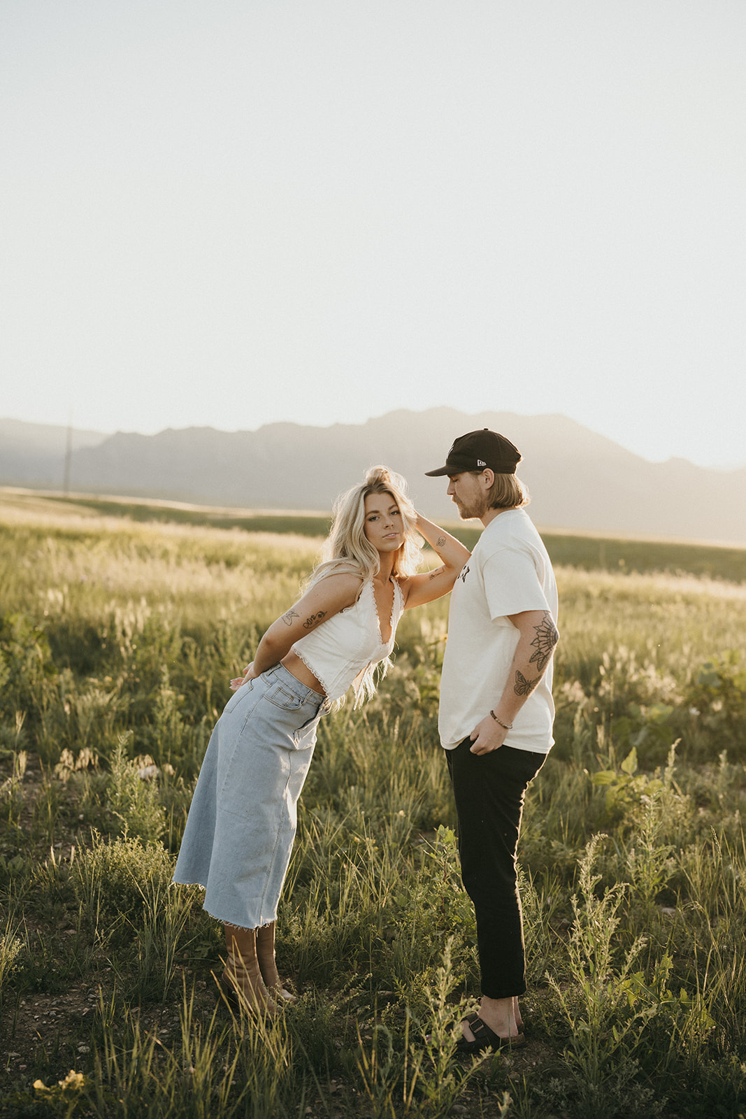 Engagement session in a big open field mountains in the background, unique couples session inspiration. 