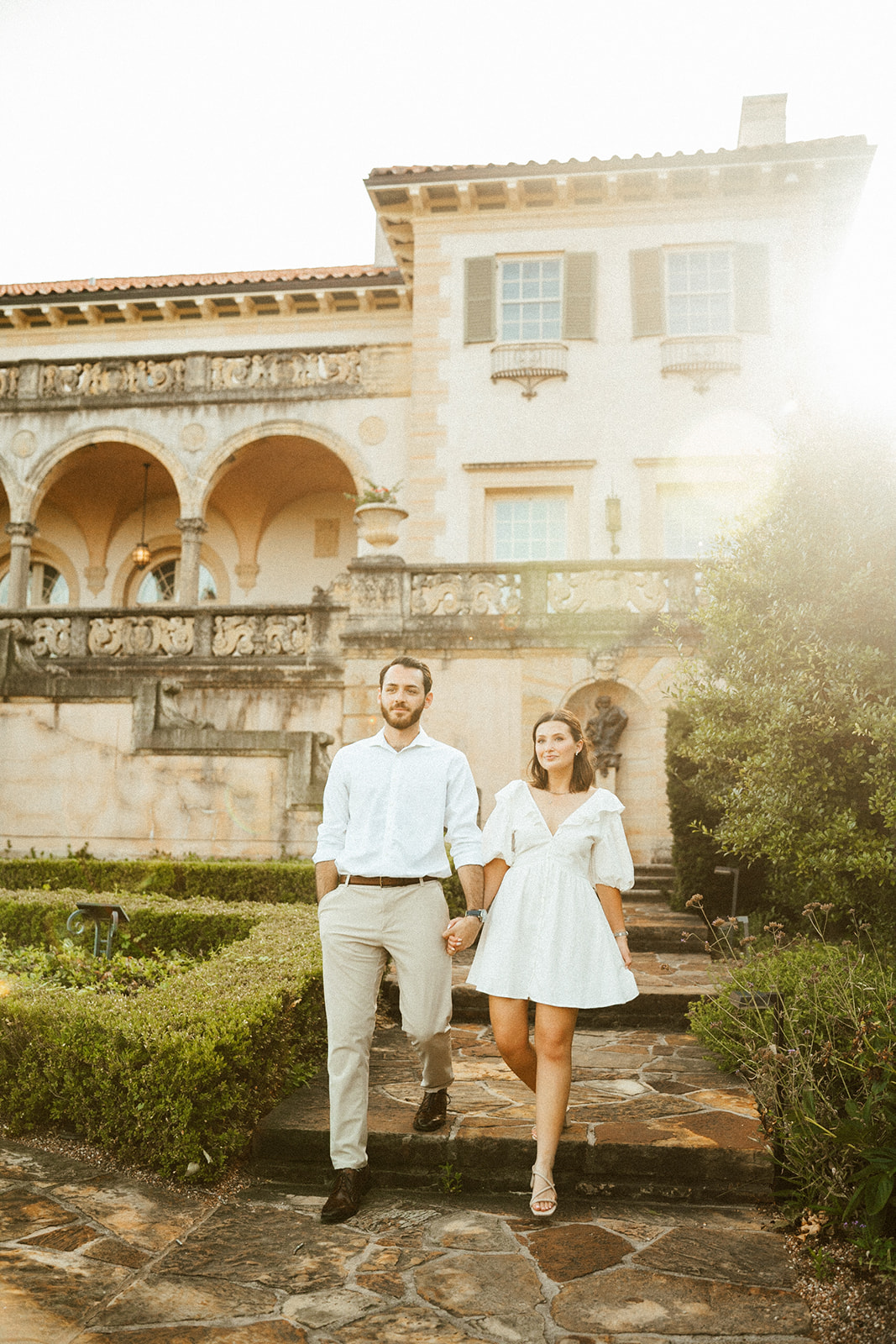 Couple walking down the steps during golden hour at Philbrook museum of art in Tulsa, Ok