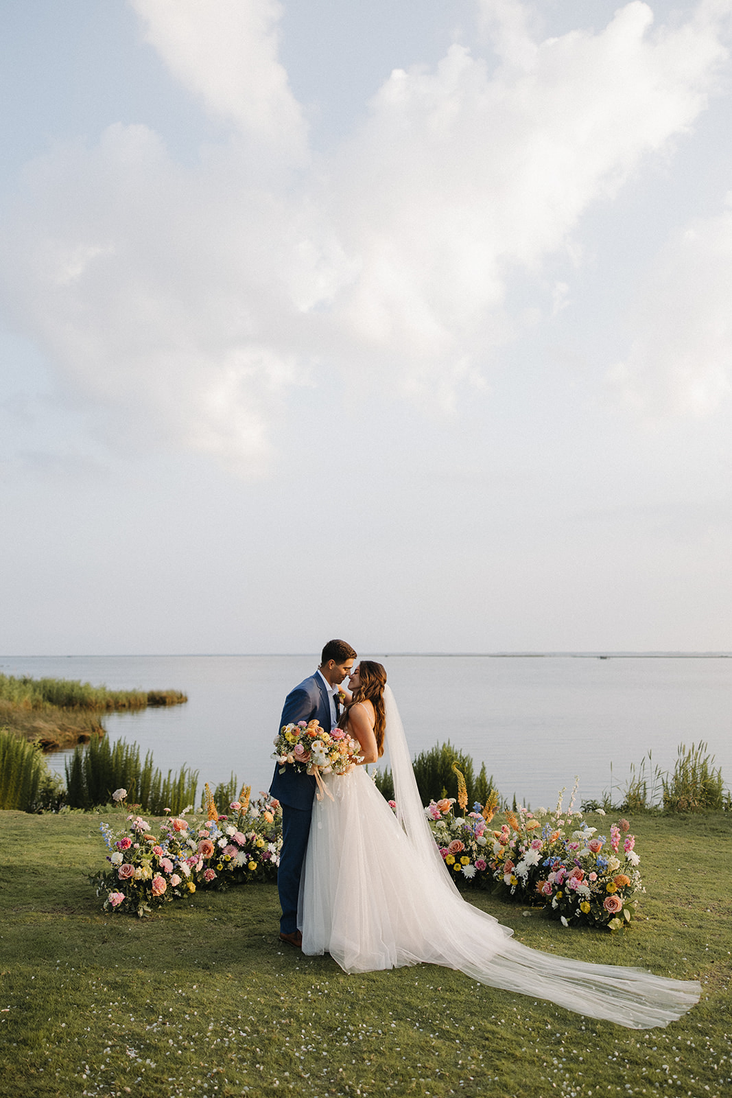 couple kisses beside wedding florals