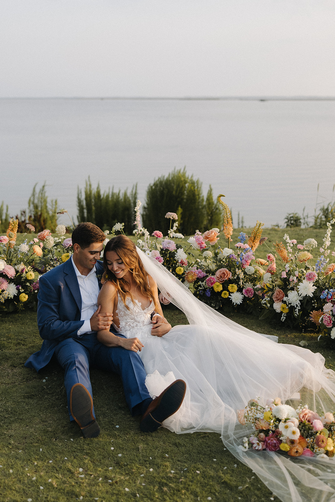 couple sits beside wedding flowers