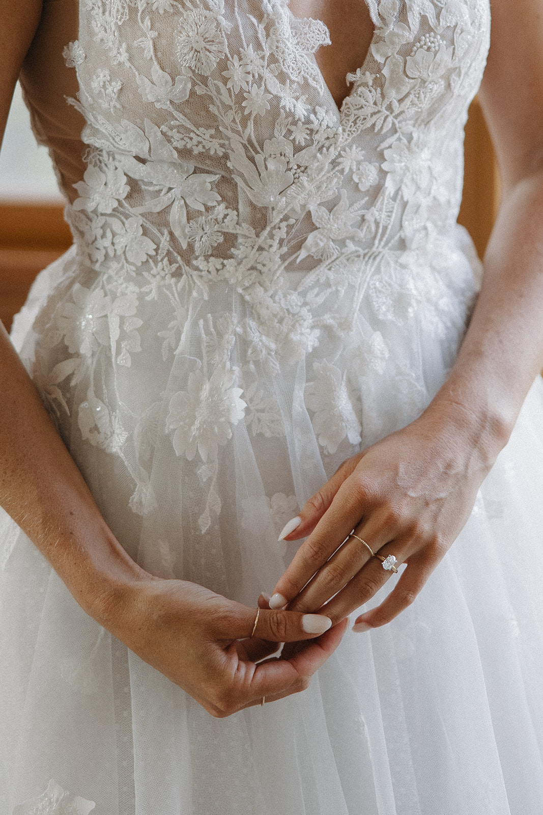 wedding rings on bride against white lace wedding dress