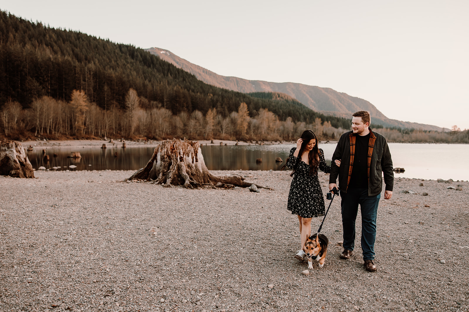 Loving couple strolling hand in hand with their dog at Rattlesnake Lake engagement session