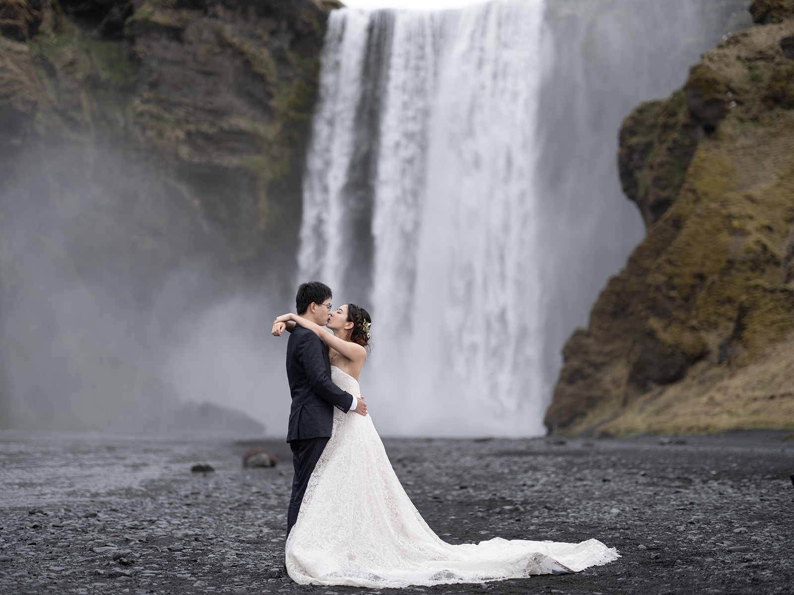 couple kissing after wedding at skogafoss waterfall