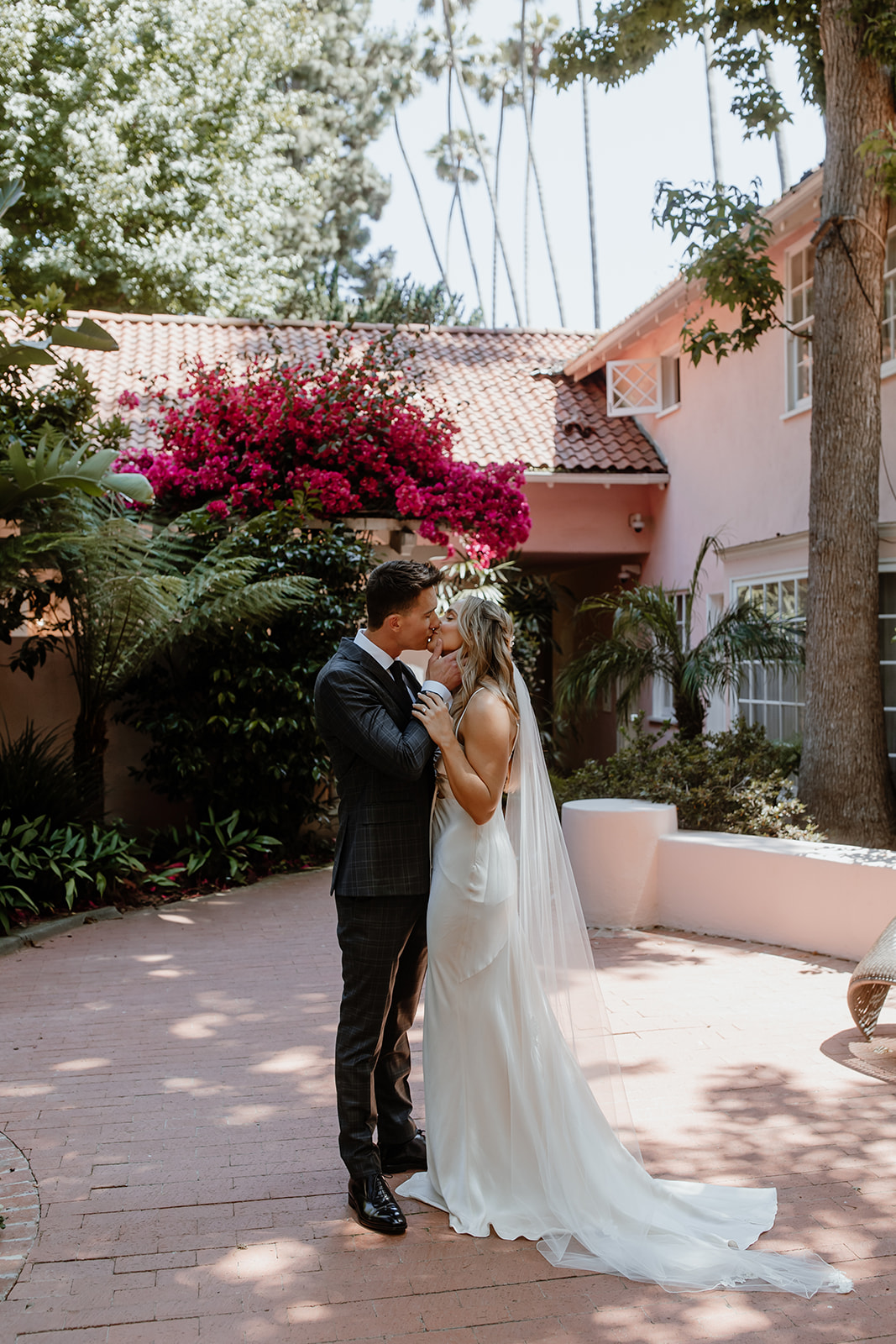 couple kissing with flowers in the background, beverly hills wedding