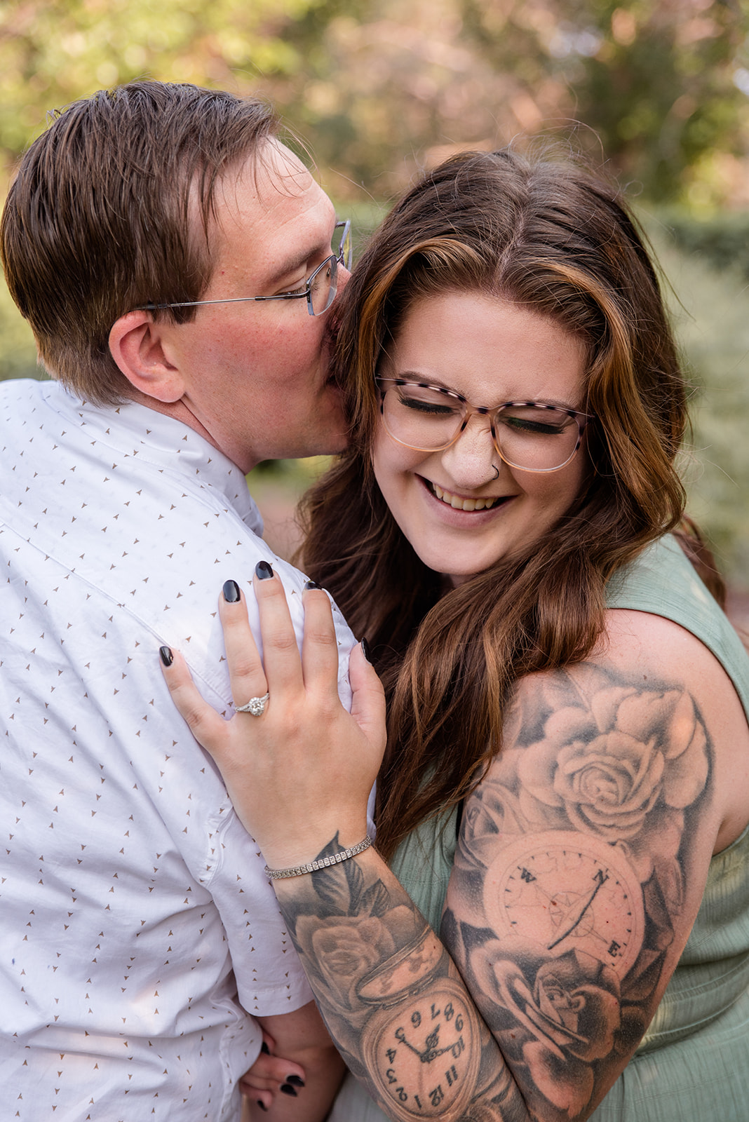 Woman laughs as her fiance whispers in her ear during engagement photos in Minnesota