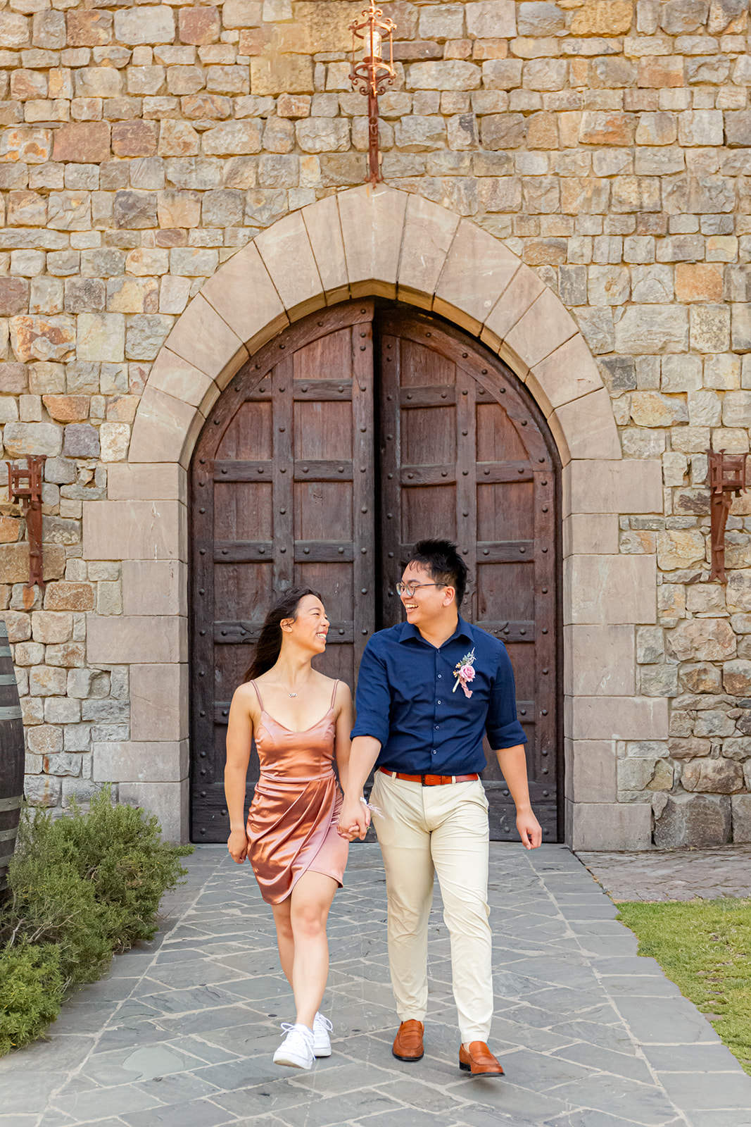 nonbinary person and their fiancée walking in front of a castle door