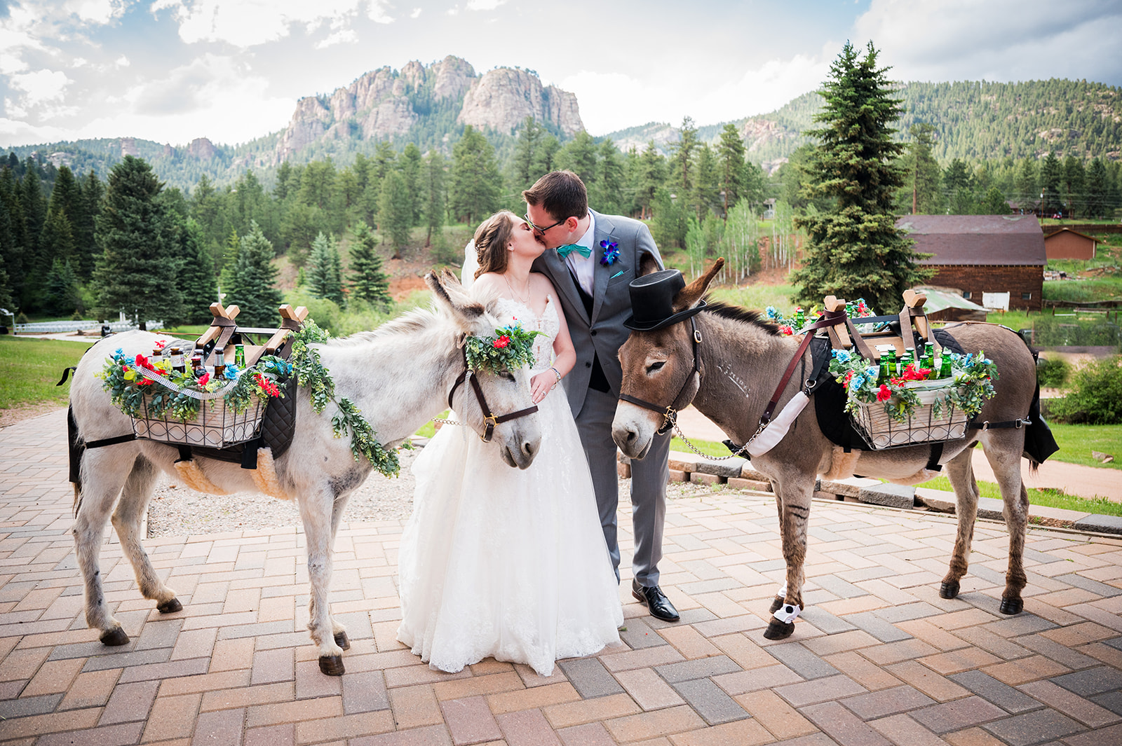 The bride and groom share a kiss holding beverage burros on either side of them.
