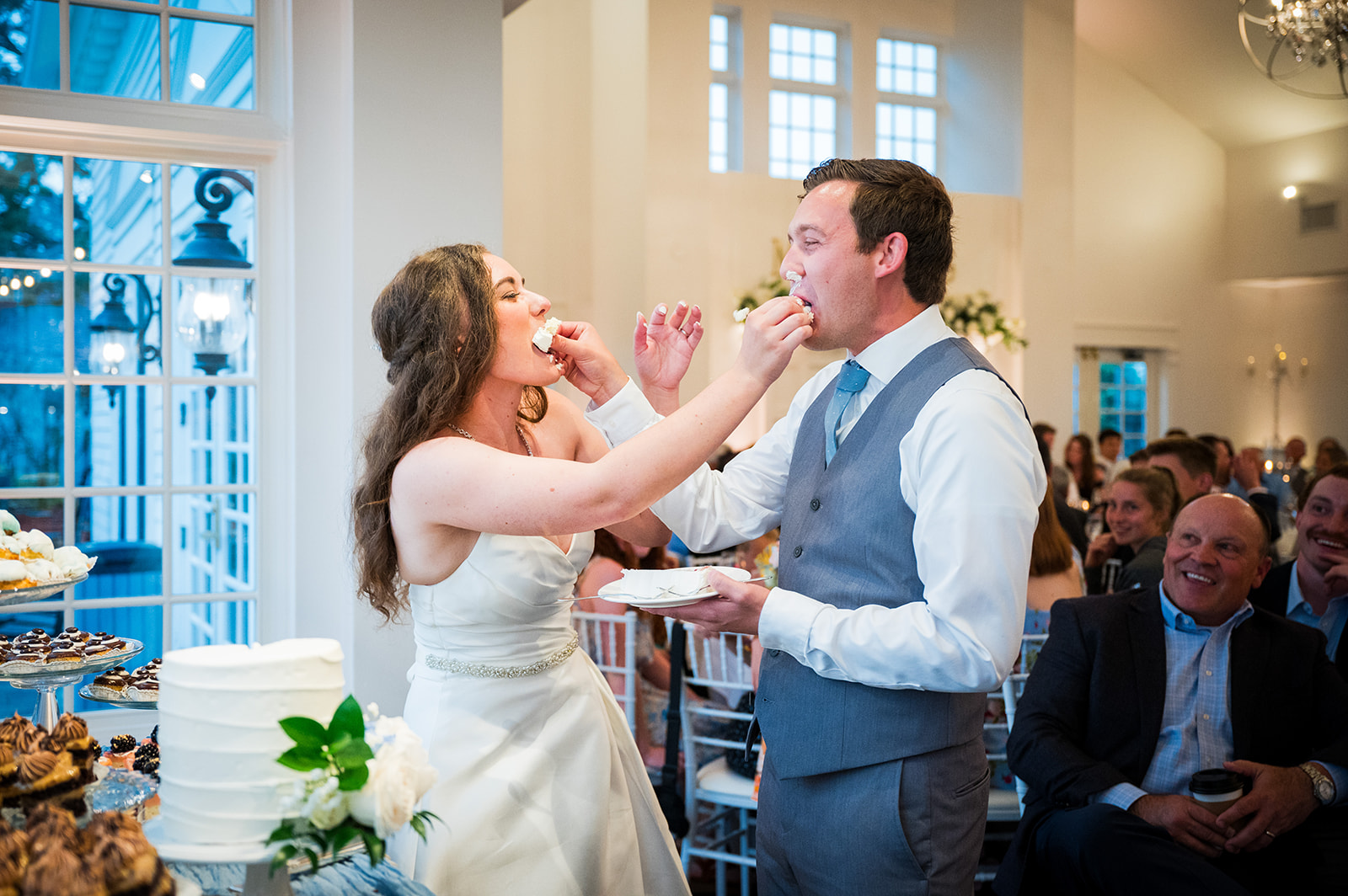 Bride and groom feed each other cake at their wedding.