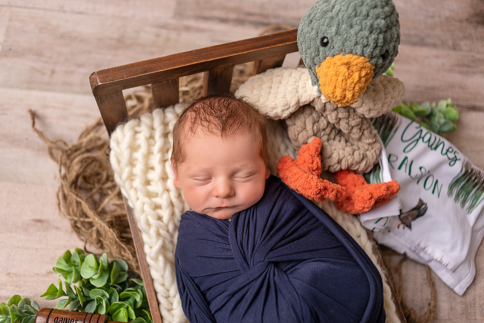 Newborn boy in Celesta Champagne Photography studio in Carthage, Missouri with fishing equipment and a crochet duck