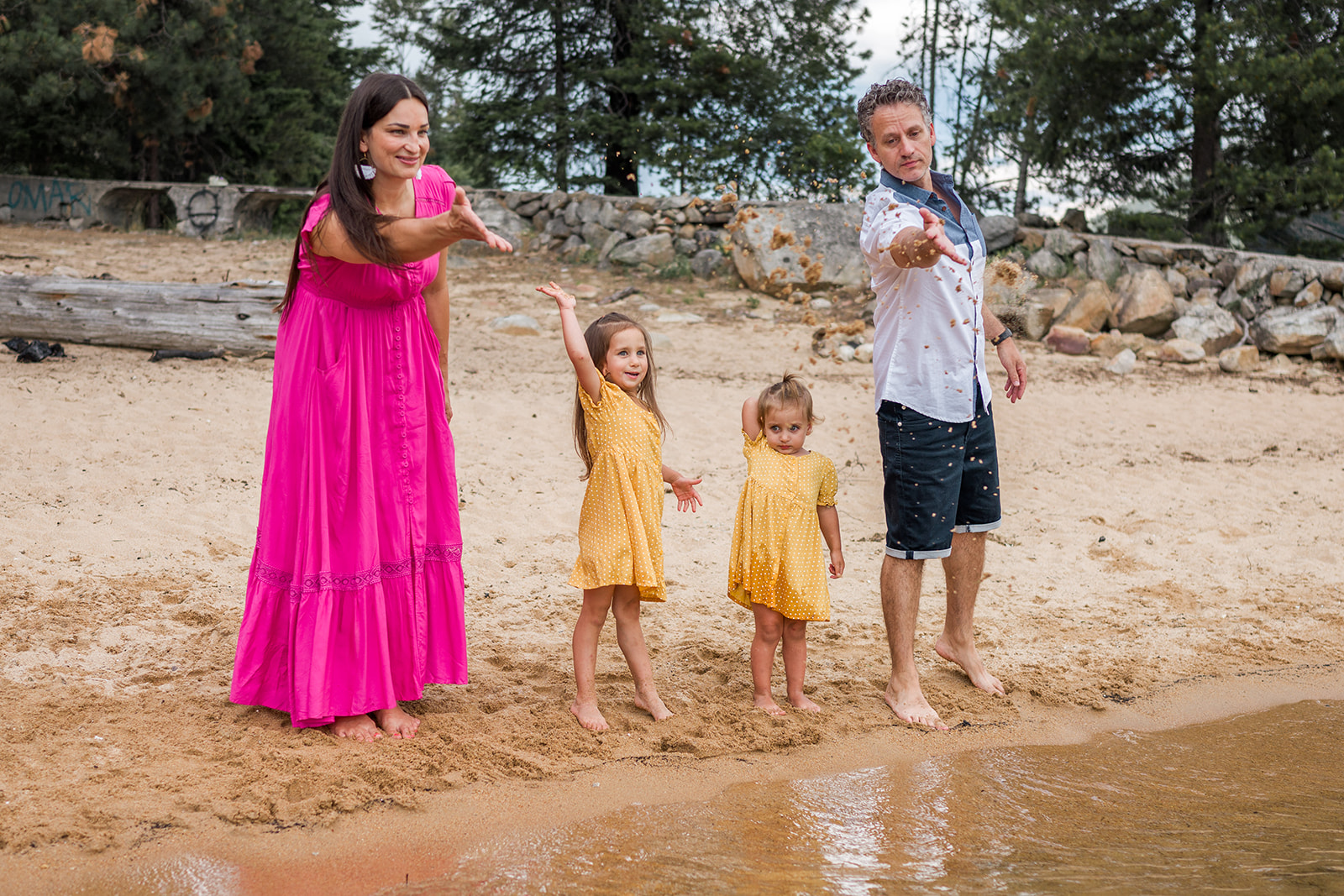 family throwing sand into Kootenay Lake