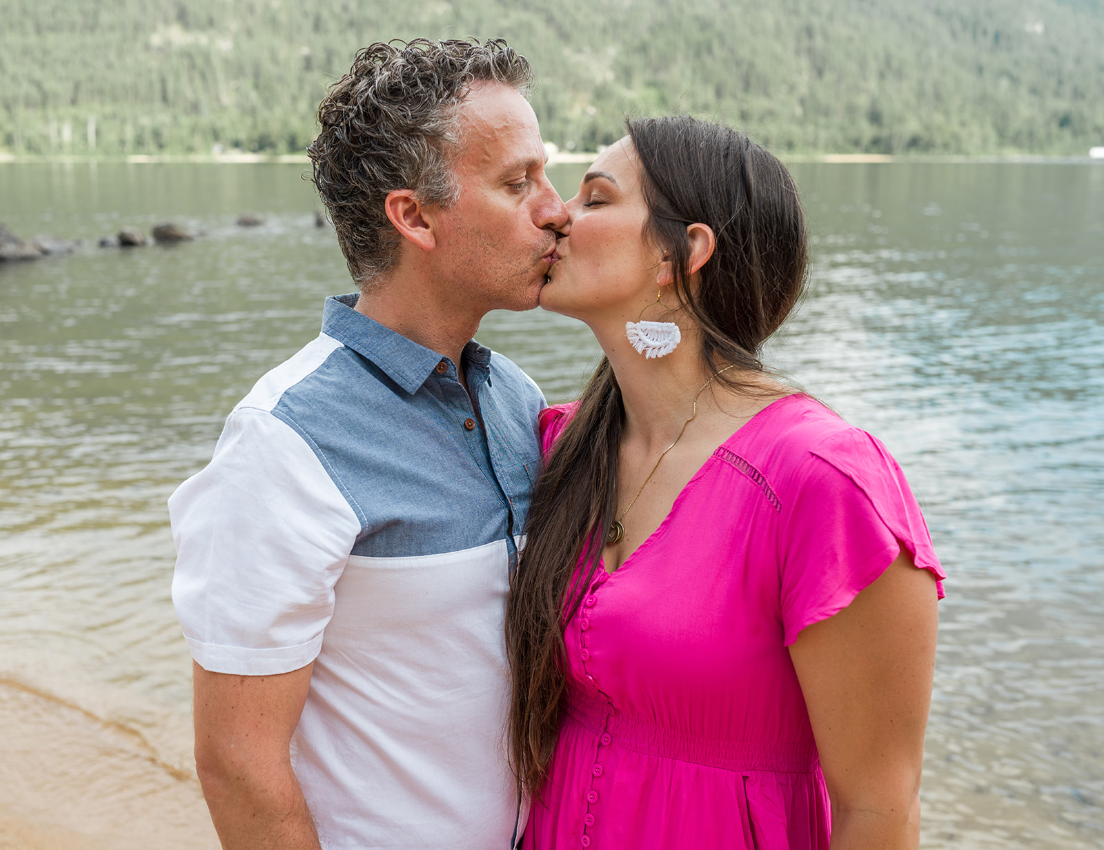 mom and dad kissing in front of Kootenay Lake