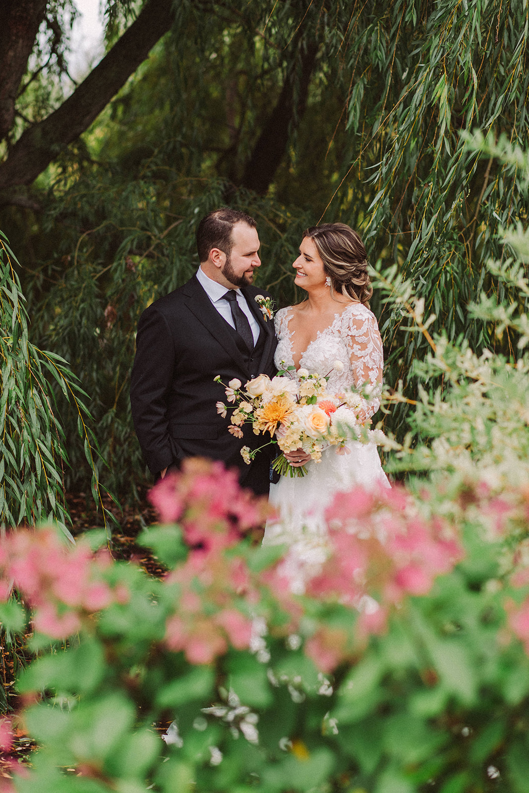 Sweet and timeless wedding portraits of a bride and groom under the huge willow tree at Aurora Cellars