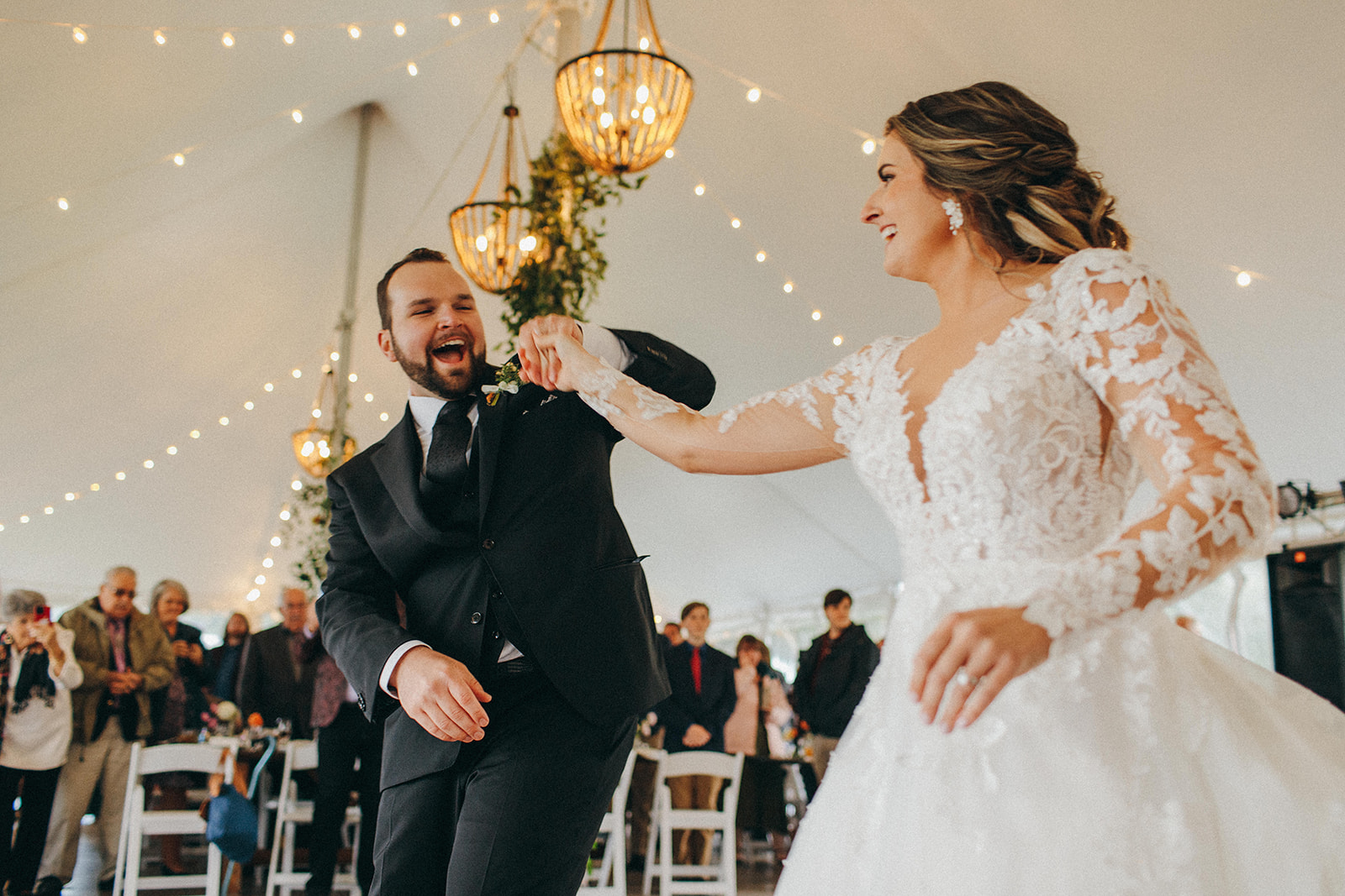A bride and groom share their first dance under their tented reception during their Fall October wedding Up North 