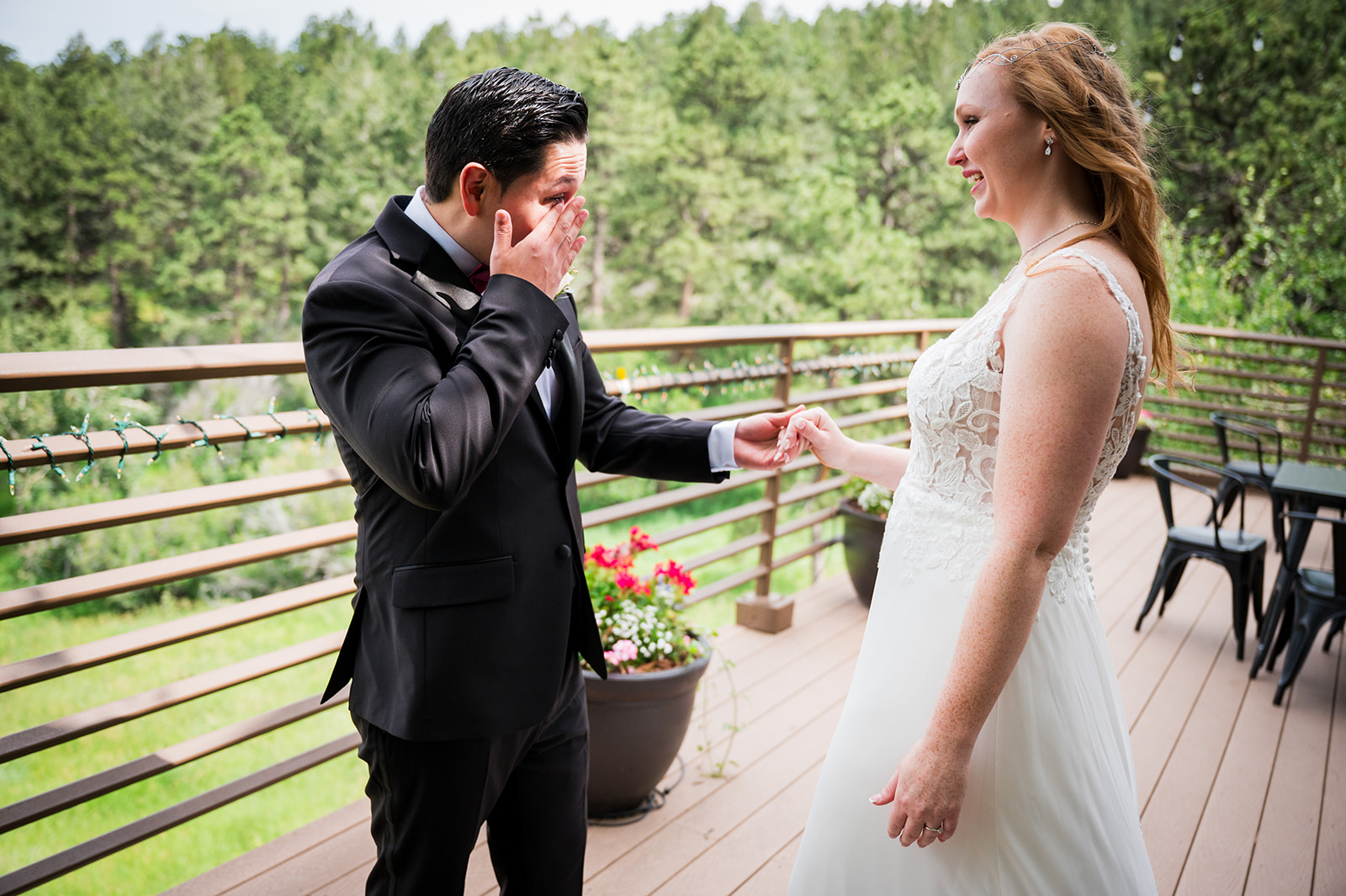 The groom wipes away a tear as he sees his bride for the first time on their wedding day.