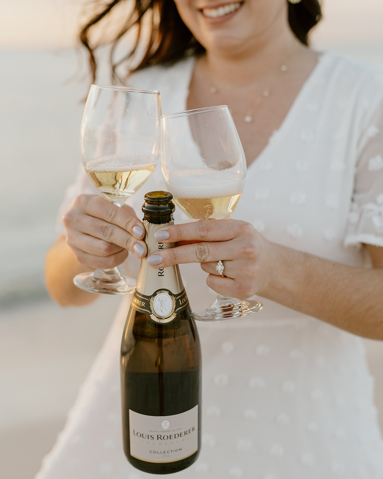 woman holding bottle of champagne and wine glasses