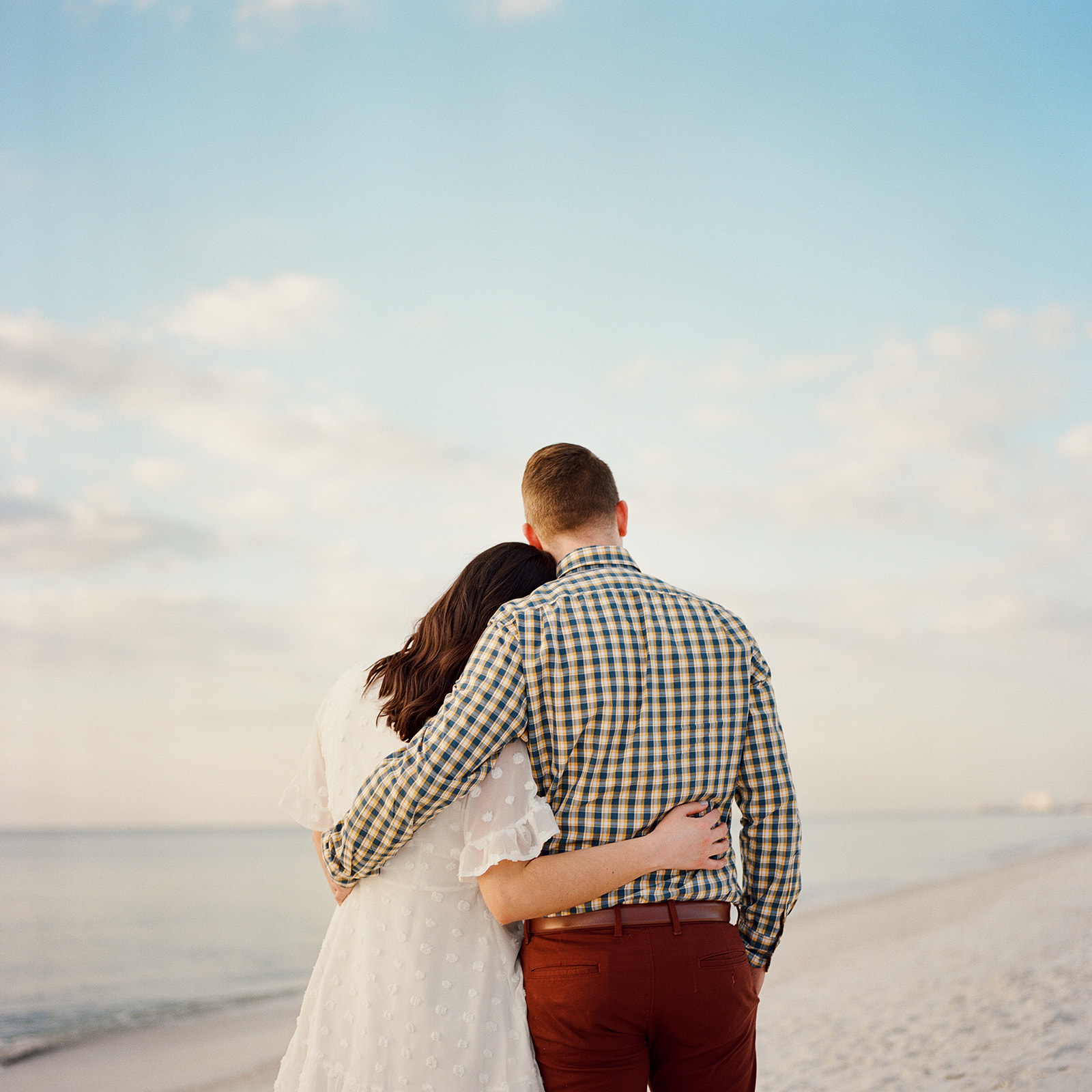 couple embracing in front of the ocean