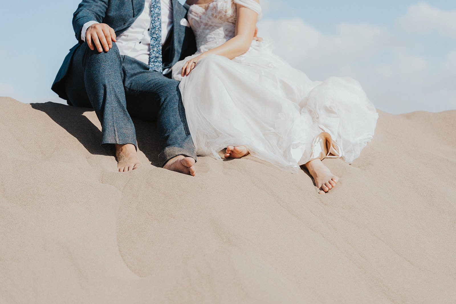 Death Valley elopement vogue photography with feet in sand dunes 