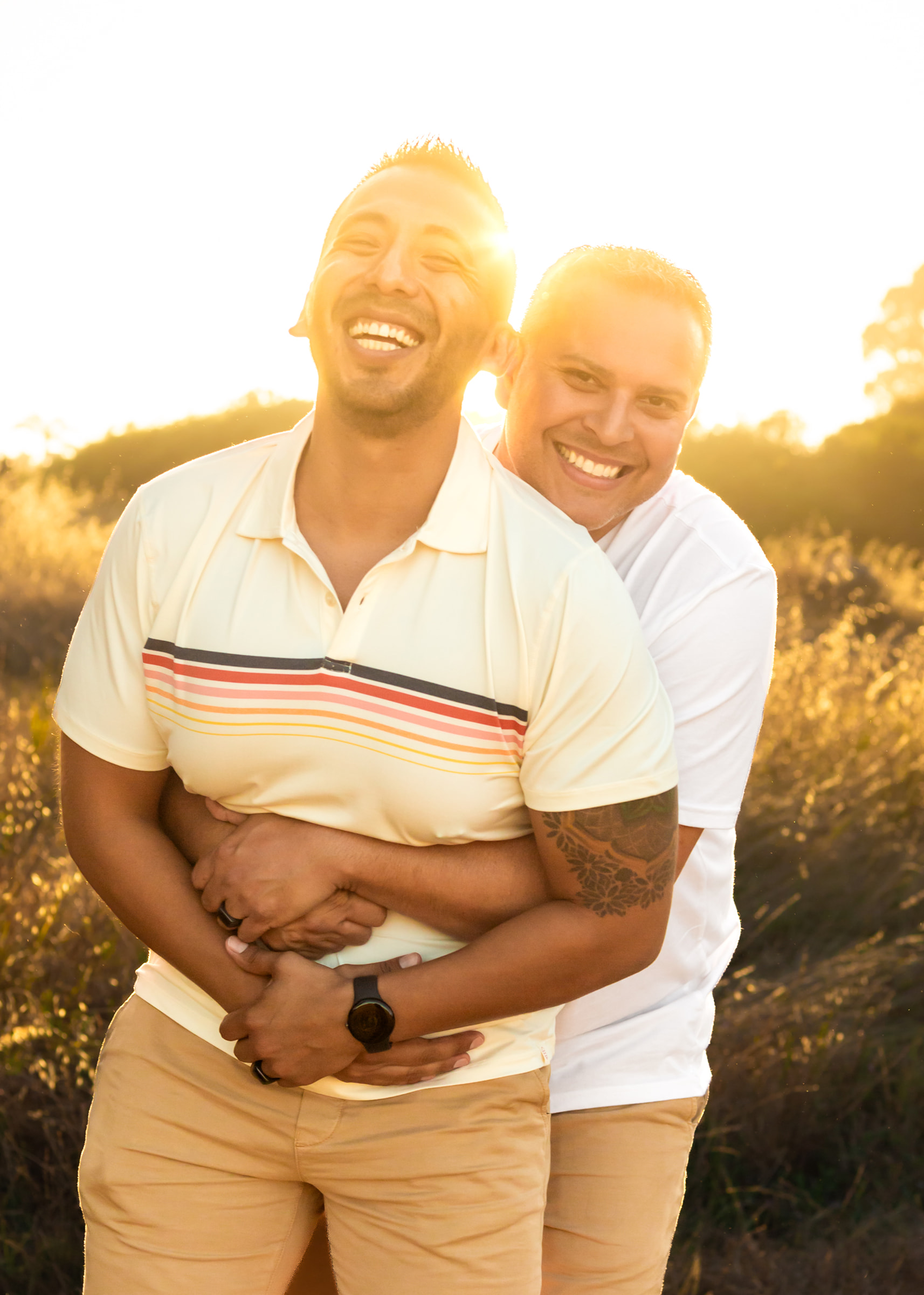 gay couple embraces during golden hour