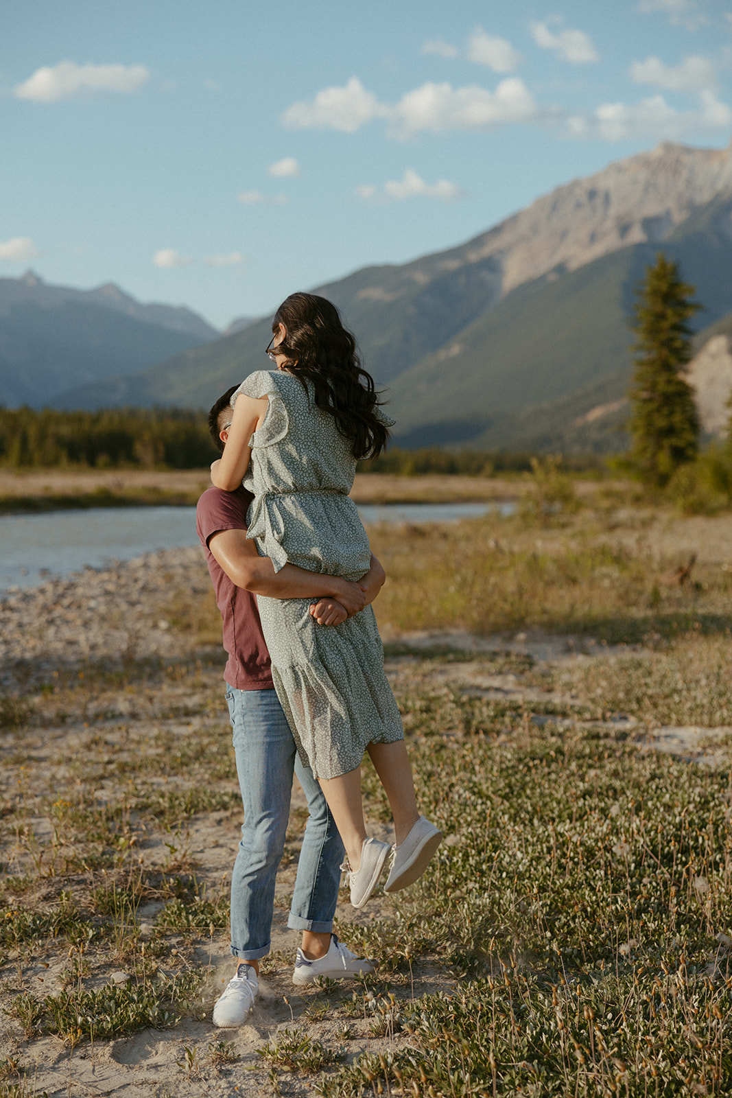 a couple who came to golden bc to get intimate engagement photos by the blaeberry river at golden hour