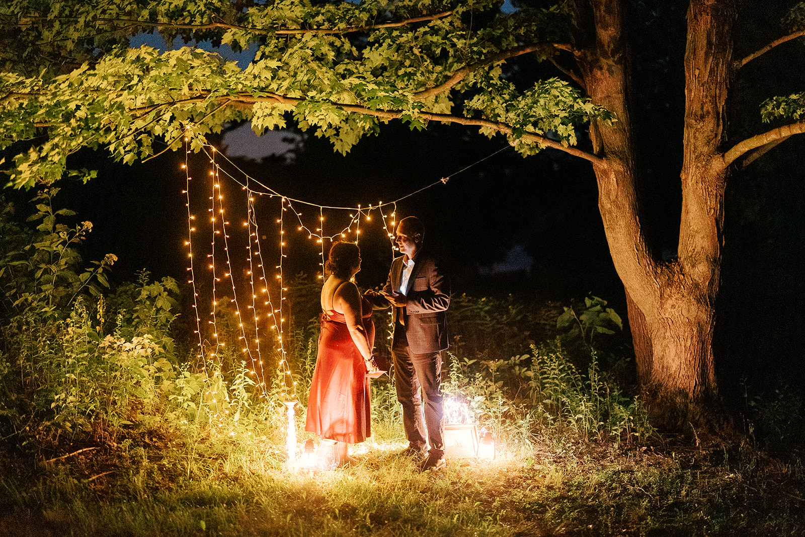 couple stands under twinkling lights at Devil's Lake State Park during their intimate night time elopement.