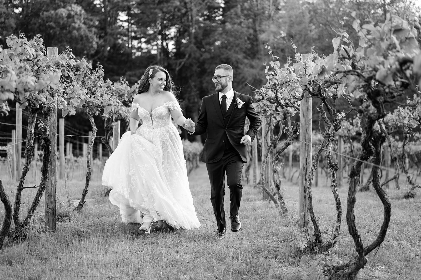 Bride and groom run through the vines