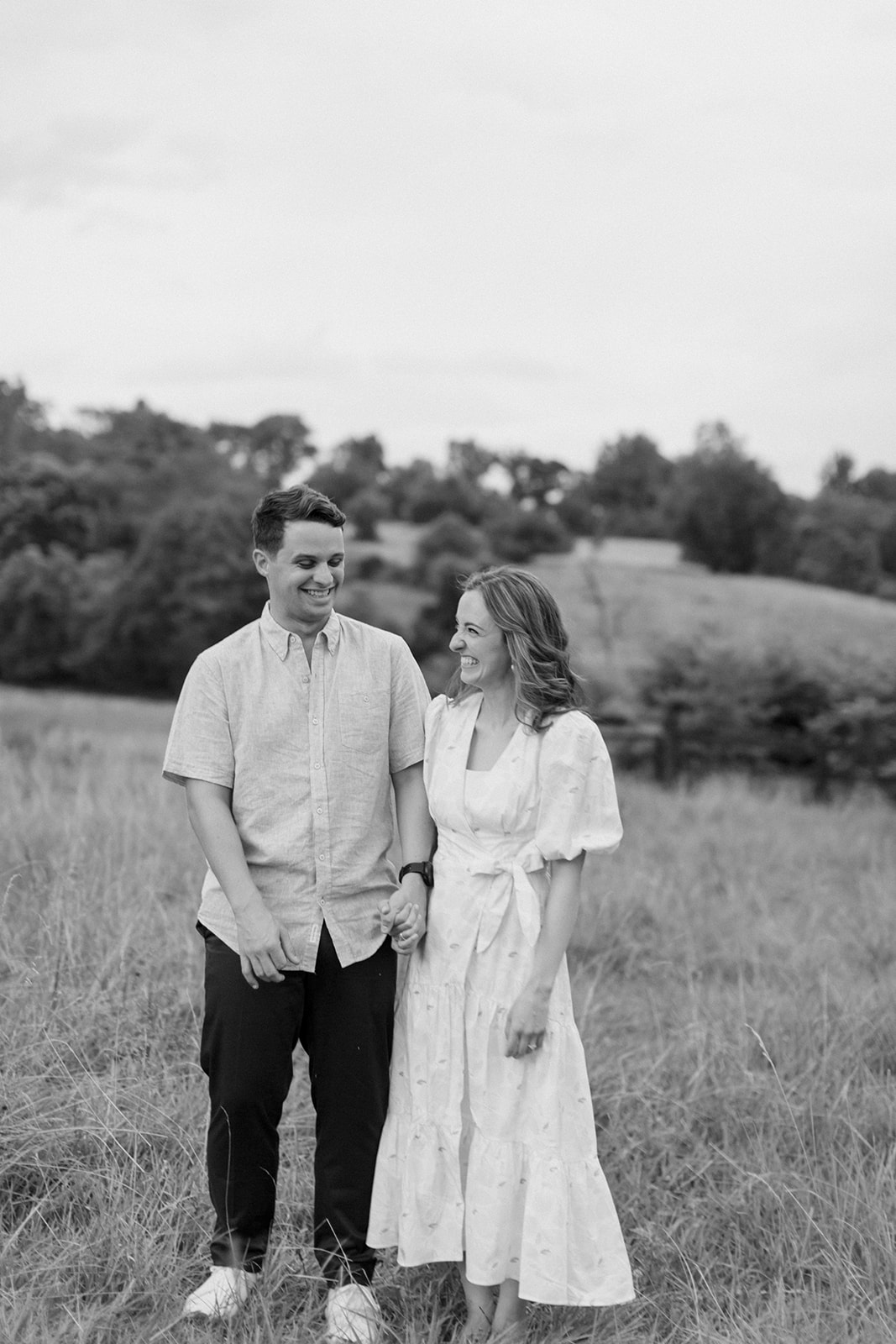 Couple stands together in field Warrenton engagement