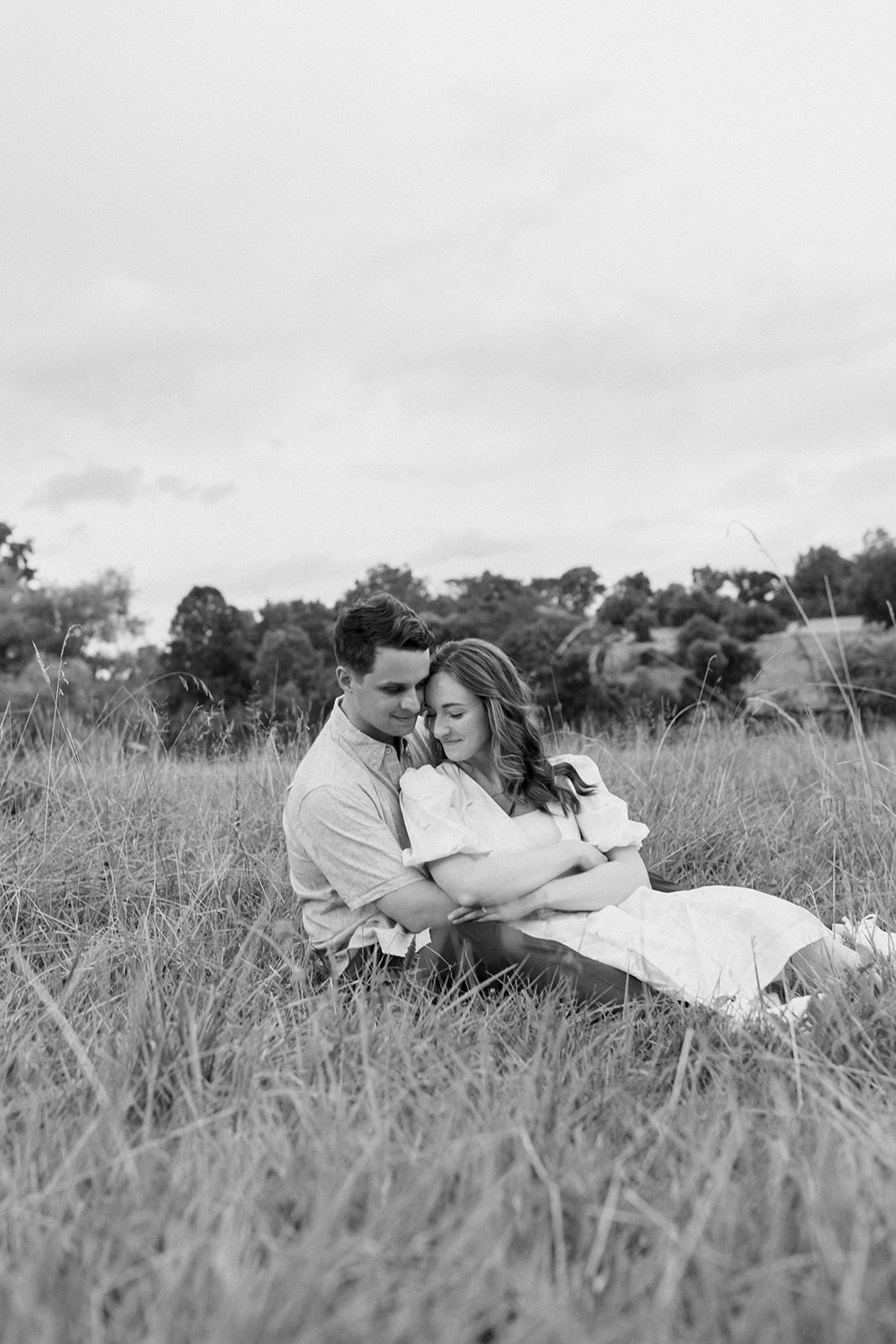 Virginia engagement session couple cuddles in an open field.
