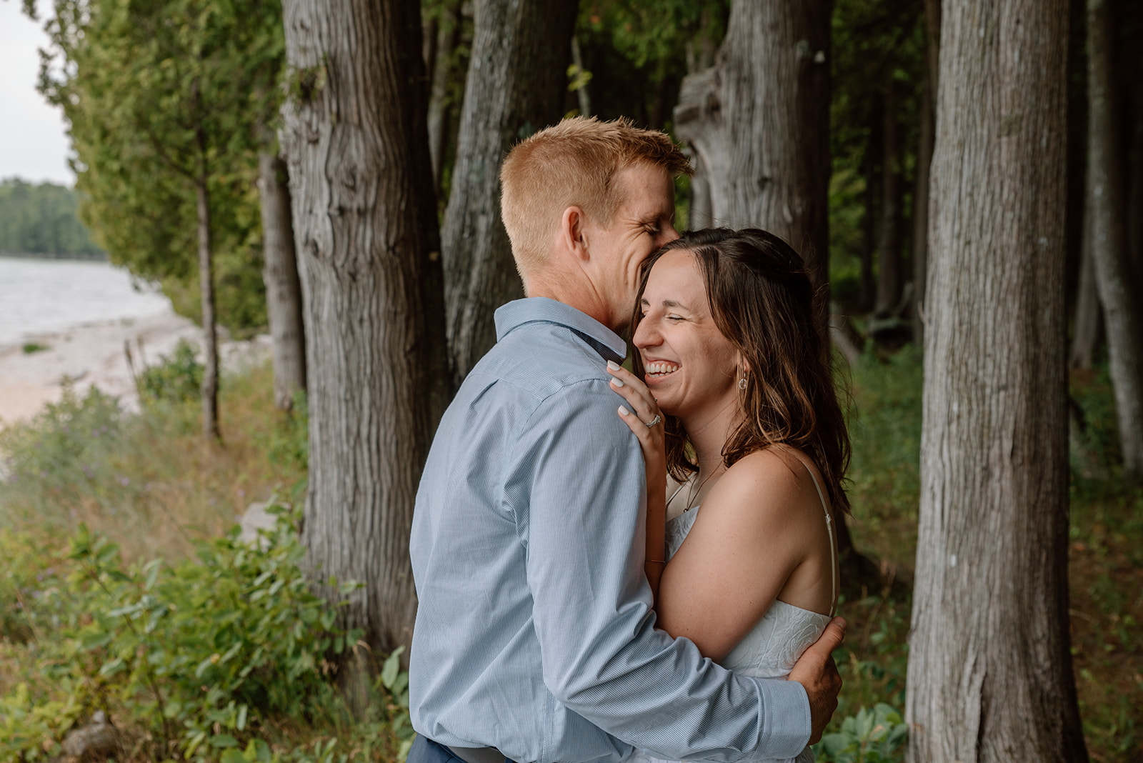 Couple laughs together during their vow renewal in the cedars of Lake Michigan
