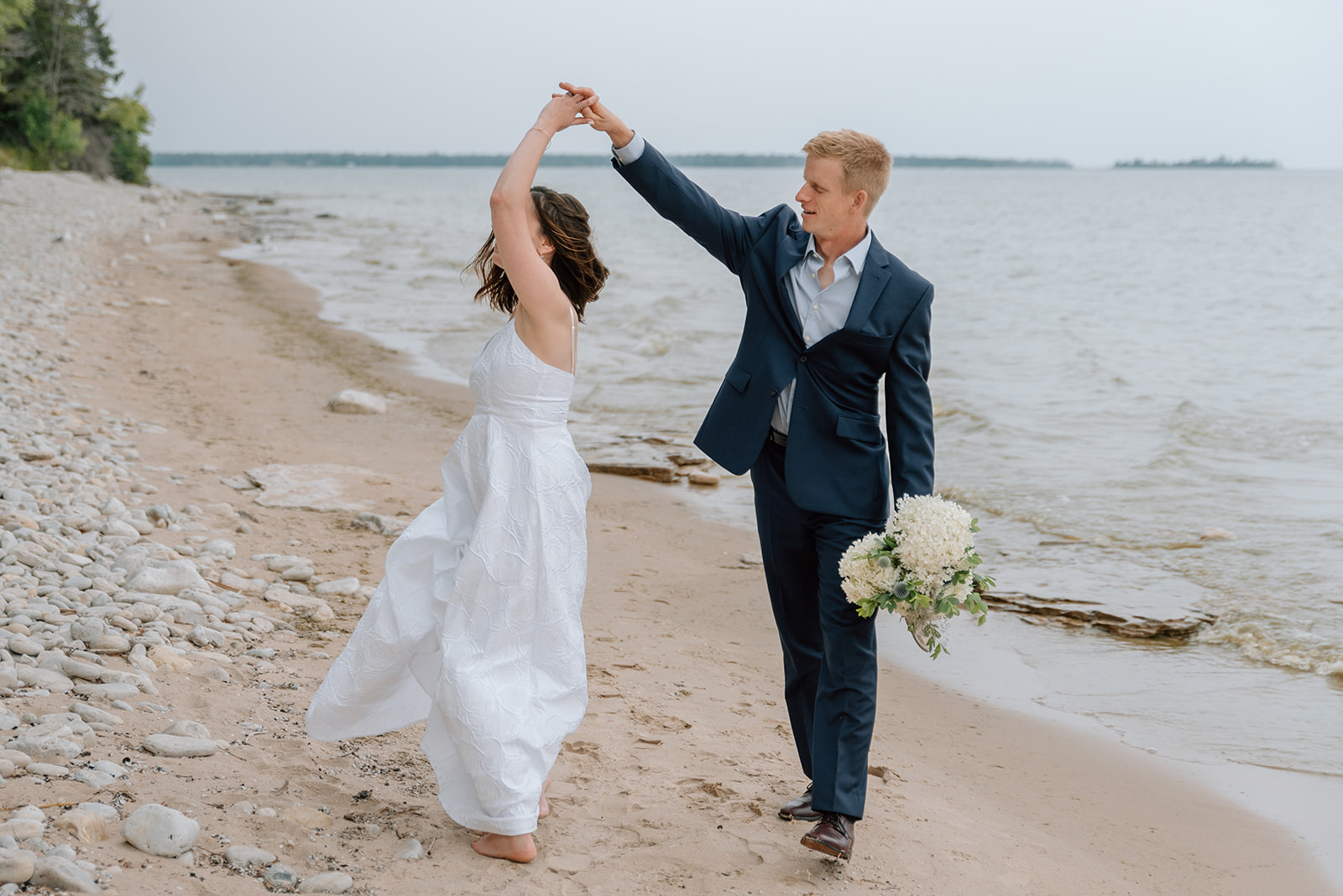 Husband and wife dance on the beach in Baileys Harbor, WI
