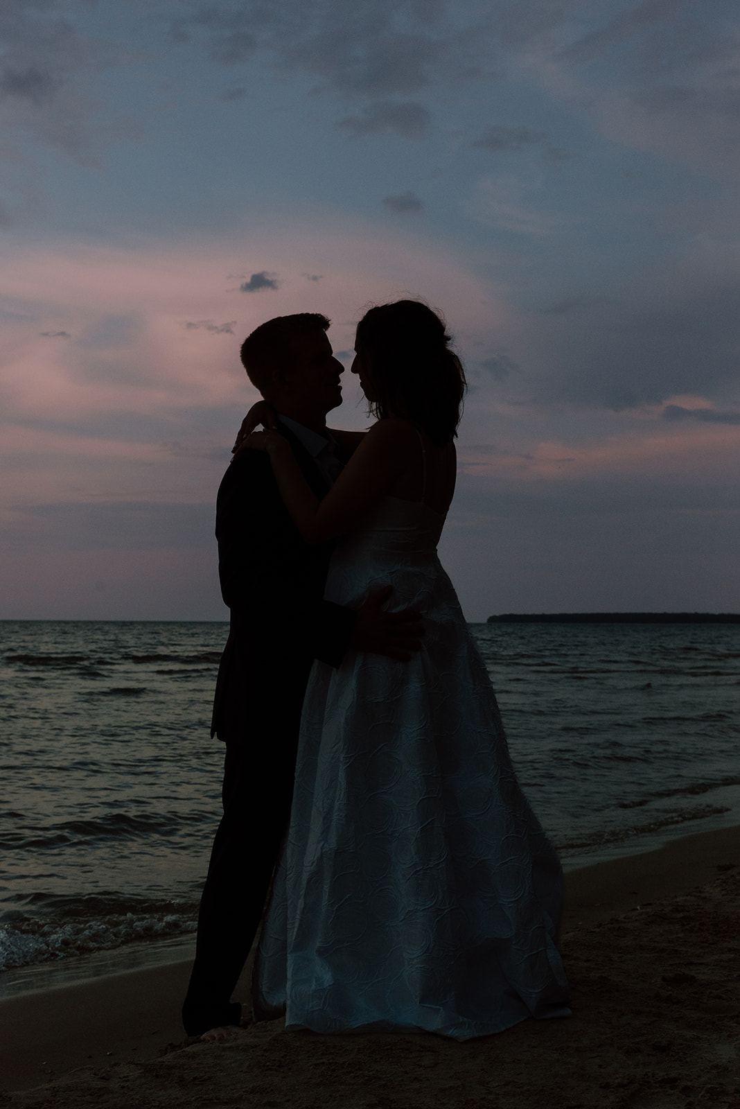 Husband and wife silhouette at sunset on Lake Michigan in Jacksonport, Wisconsin