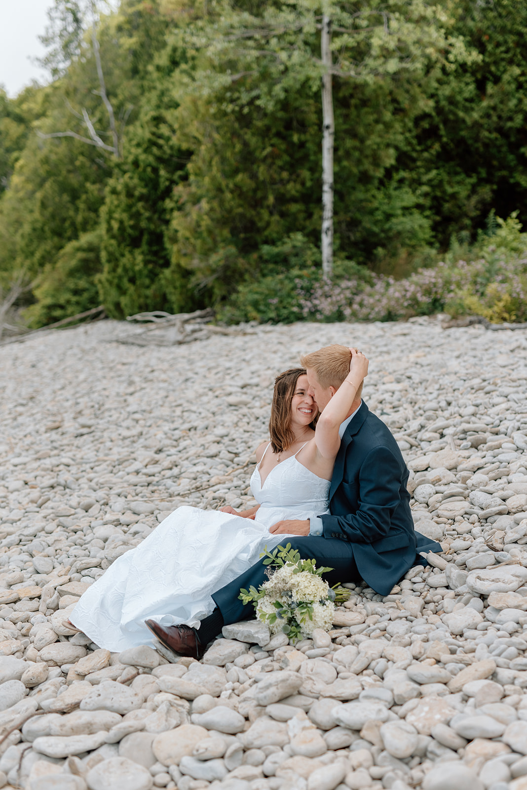 Wedding couple sits on the white rocks of Door County's Lake Michigan beach