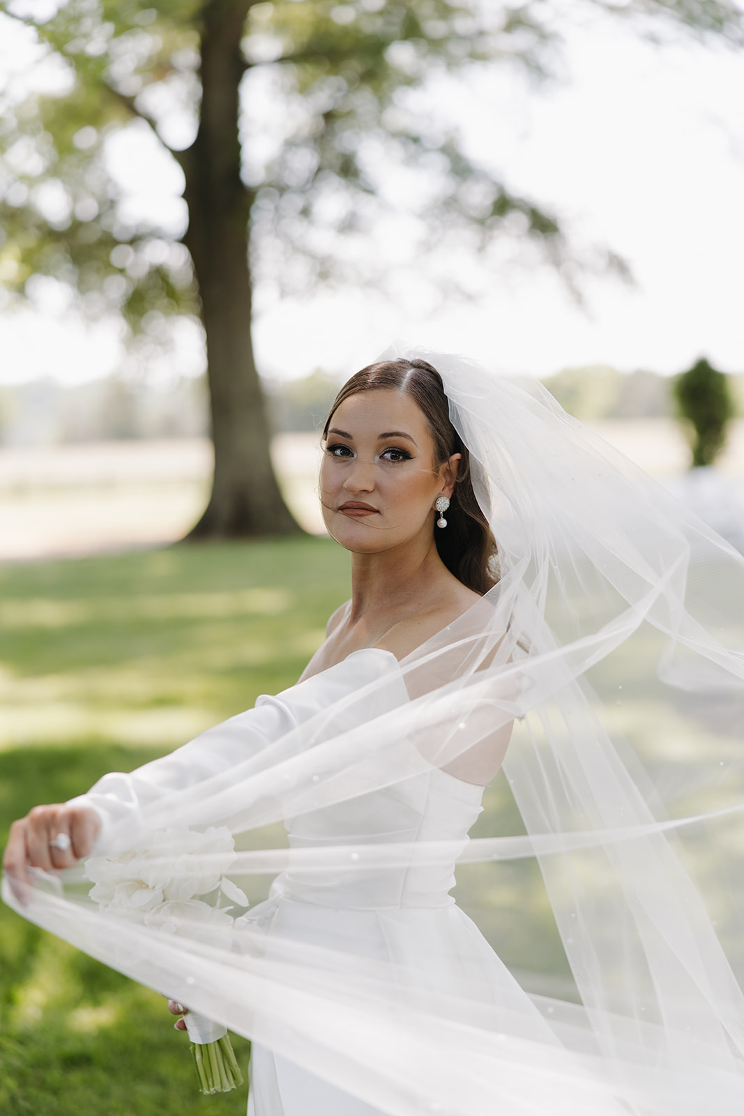 bride swirls pearl-covered wedding veil