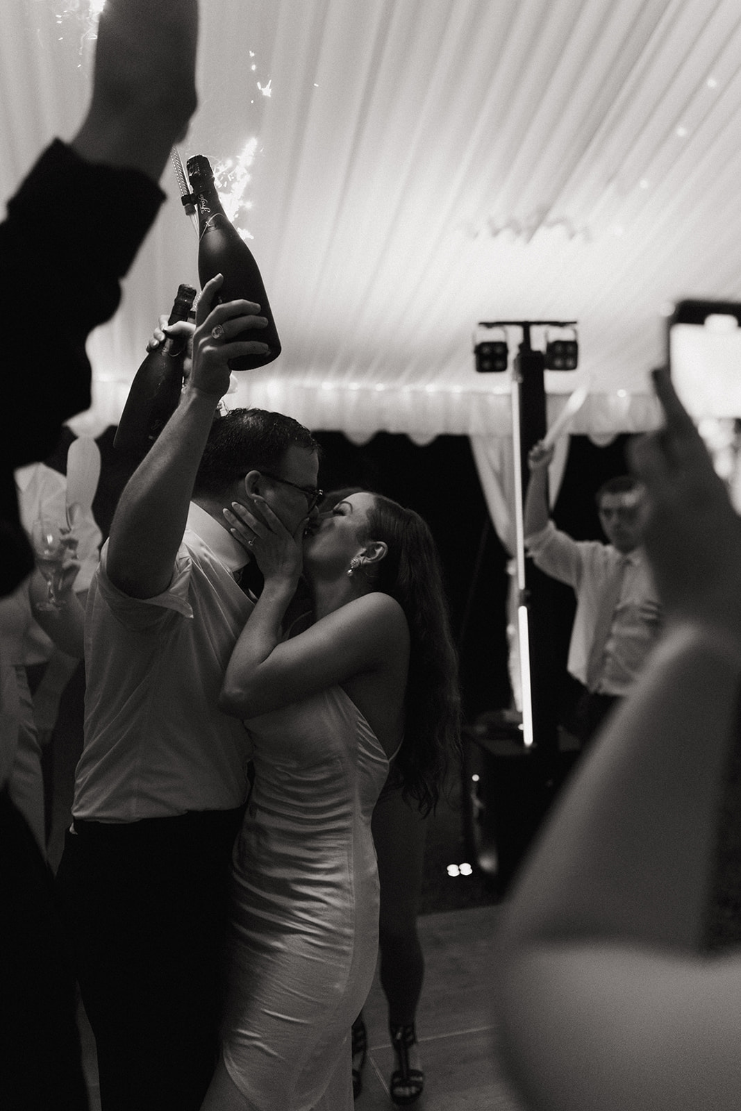 couple kisses during reception at outdoor wedding with tent
