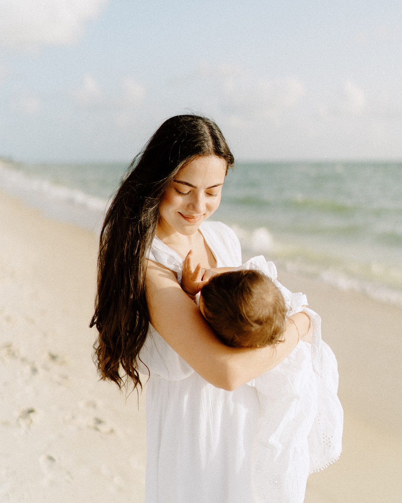 A mother breastfeeding her baby at a beach in Naples