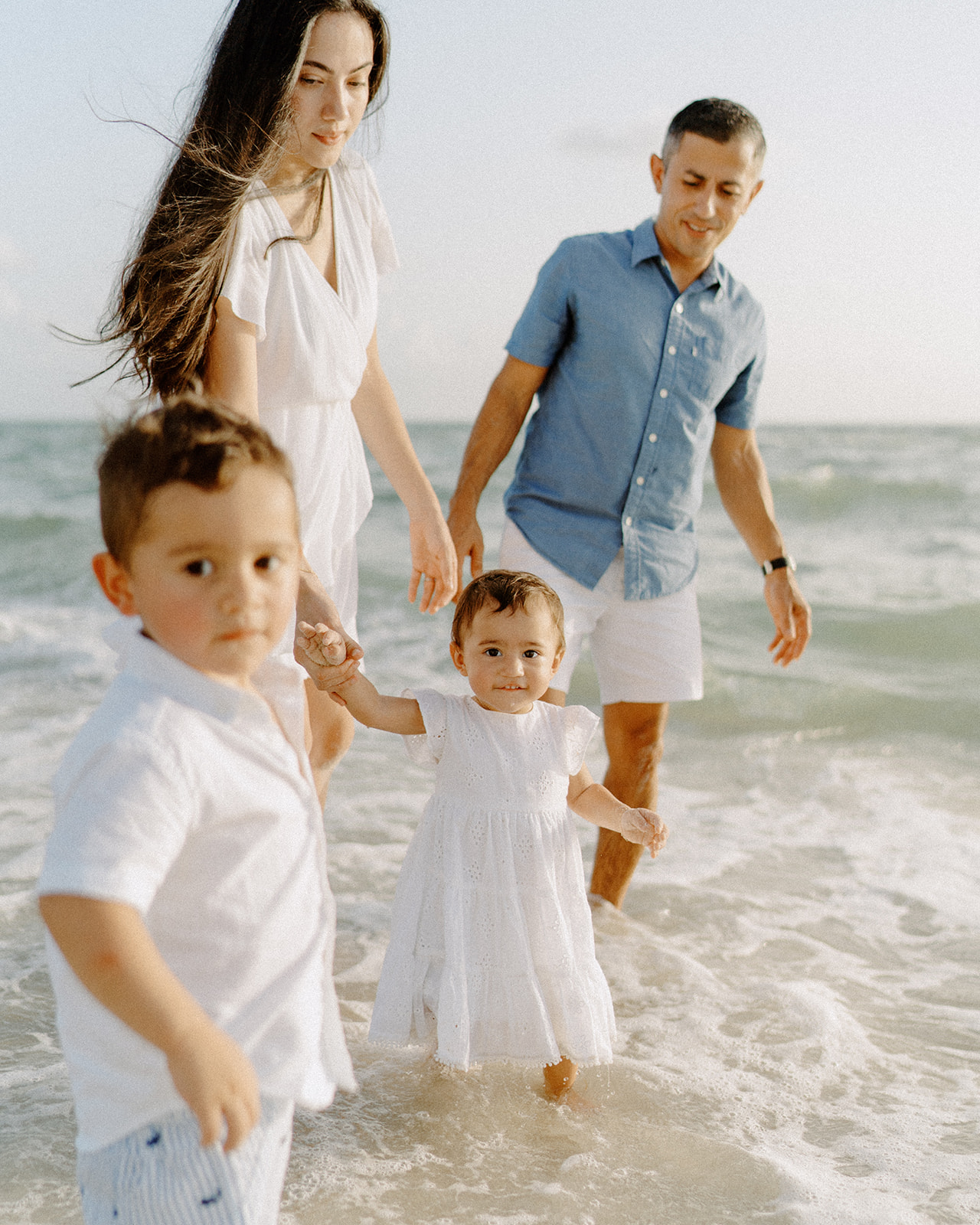 a family standing on the shore on Naples Beach