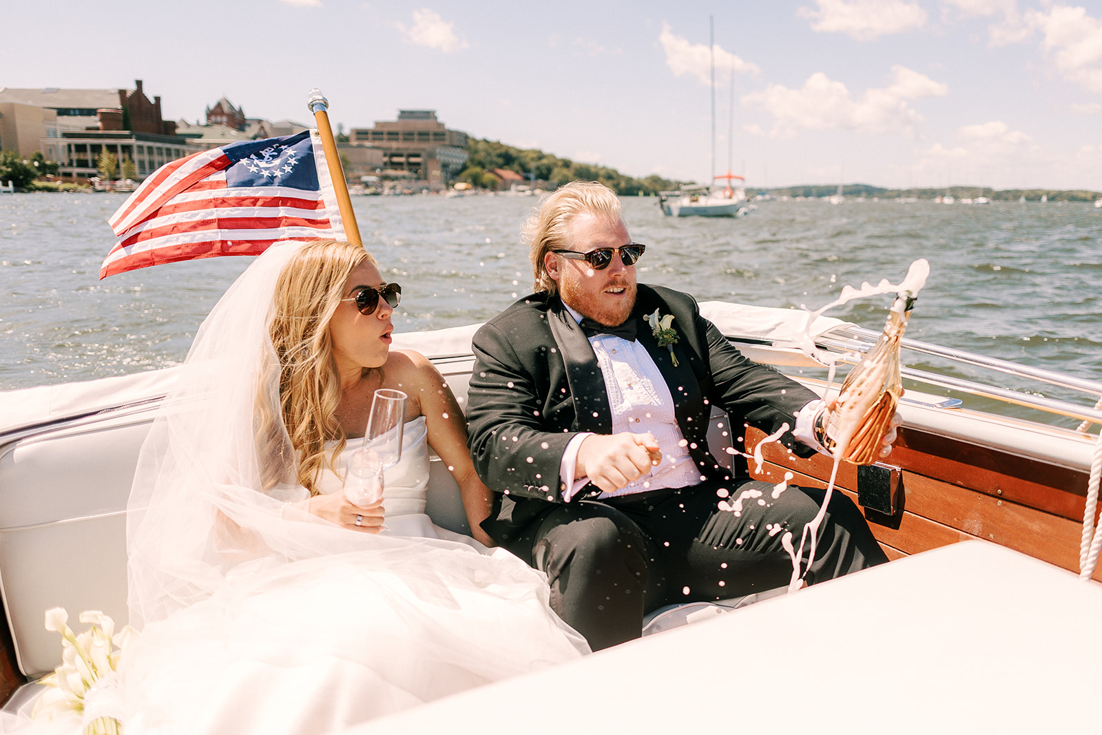 bride and groom enjoy a boat ride on lake mendota on their wedding day in madison wisconsin