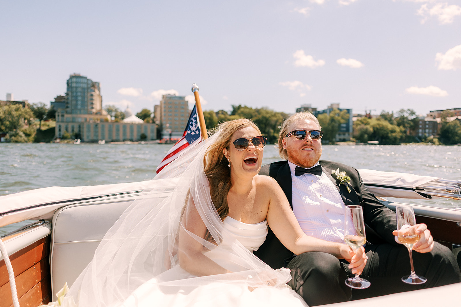 bride and groom enjoy a boat ride on lake mendota on their wedding day in madison wisconsin