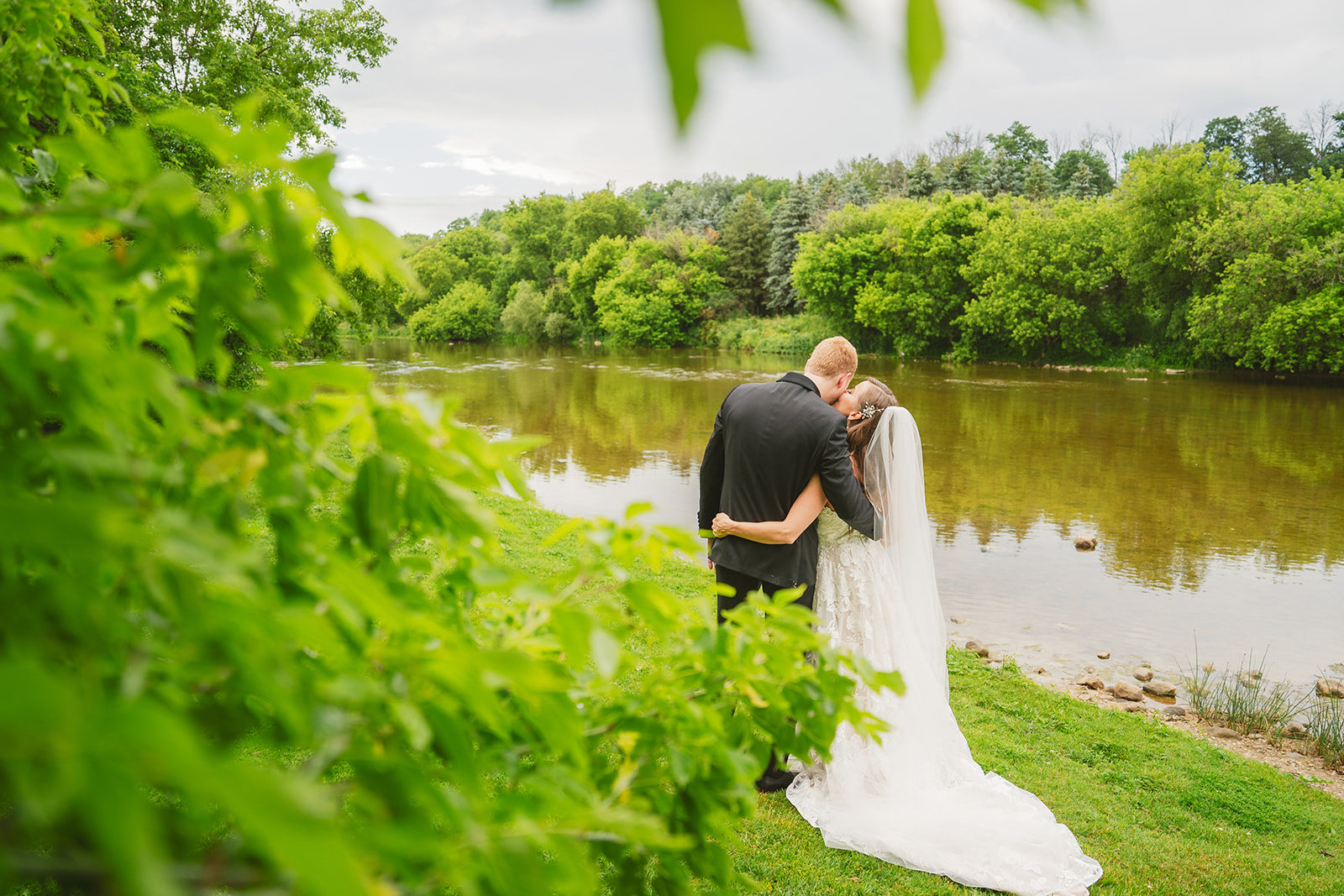 bride and groom by the river in st Jacobs