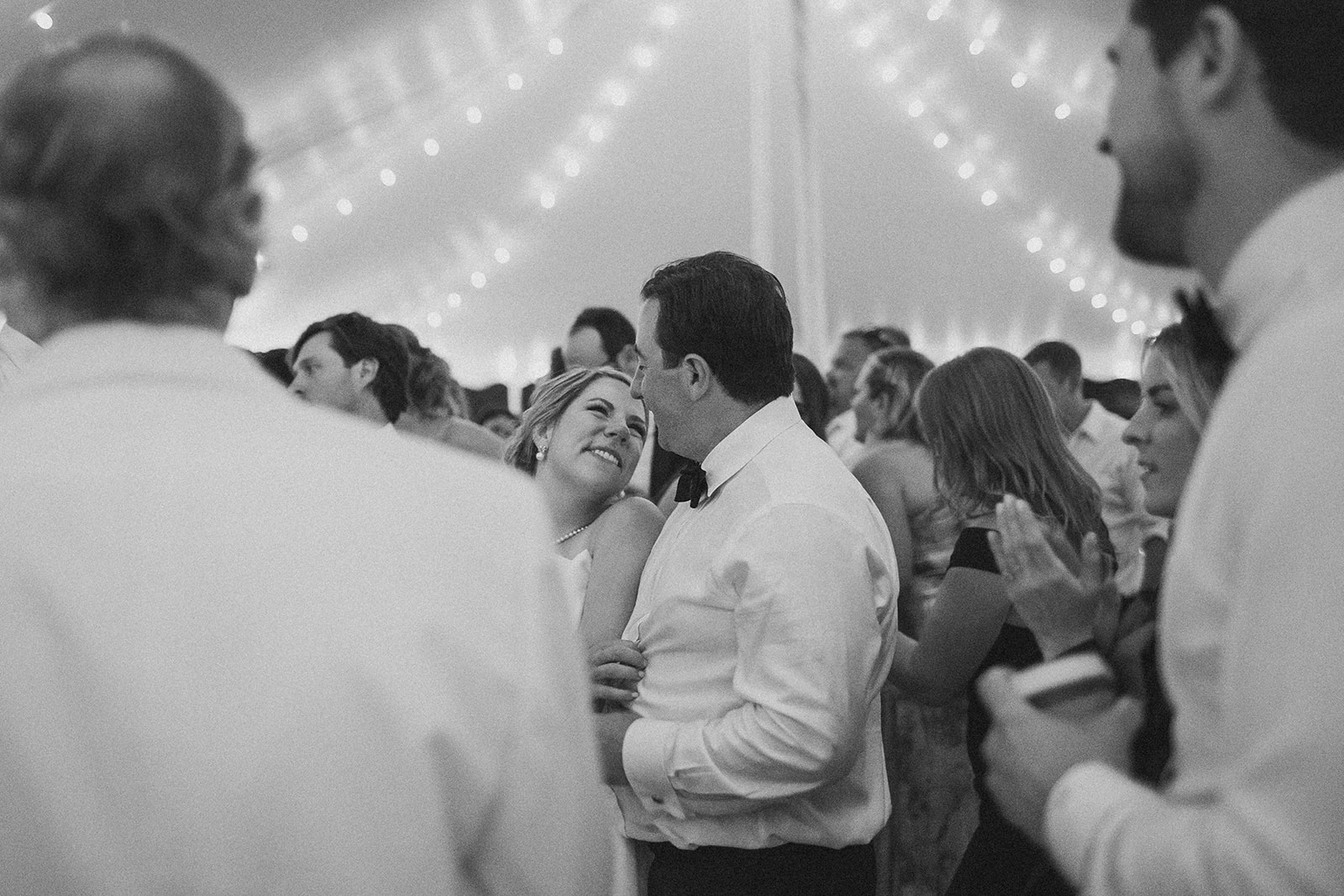 Black and white documentary wedding photographs of a couple on the dance floor of their tented reception at the Grand 