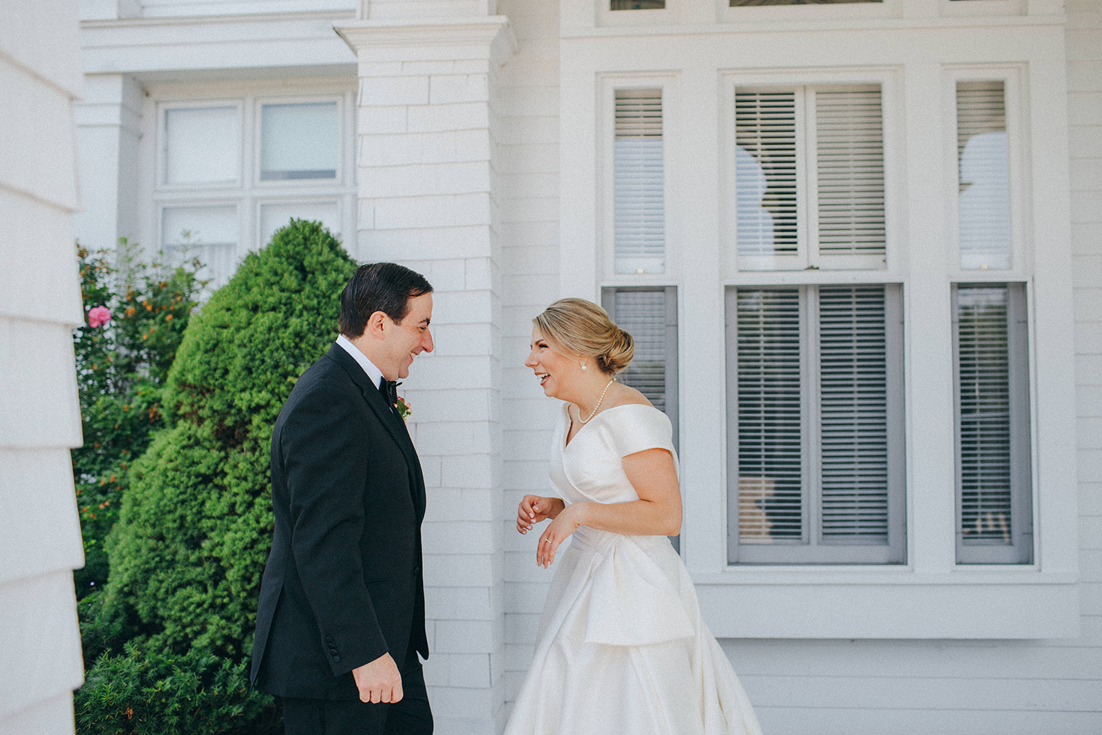 A bride and groom's first look next to the gardens at the Grand Hotel front porch 