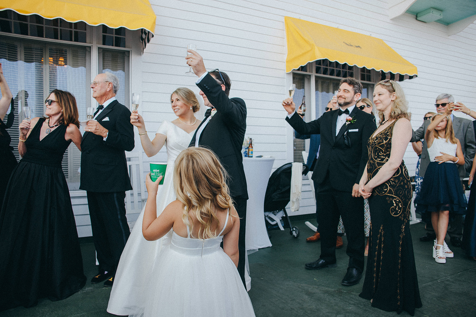 A fun and innocent moment of the flower girl toasting to the bride and groom on the Grand Hotel's largest front porch